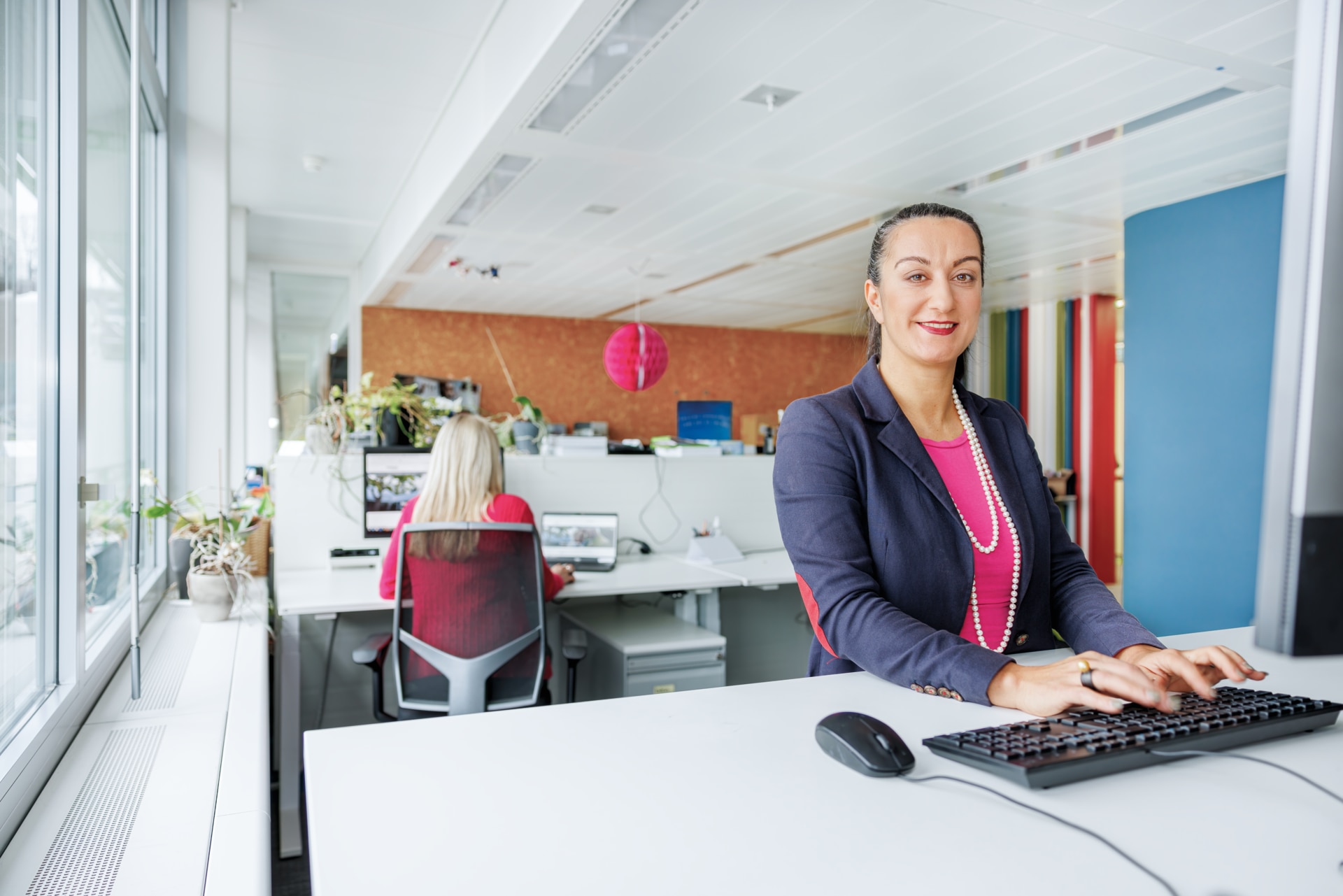 Slim − Frontansicht einer Frau am Computer