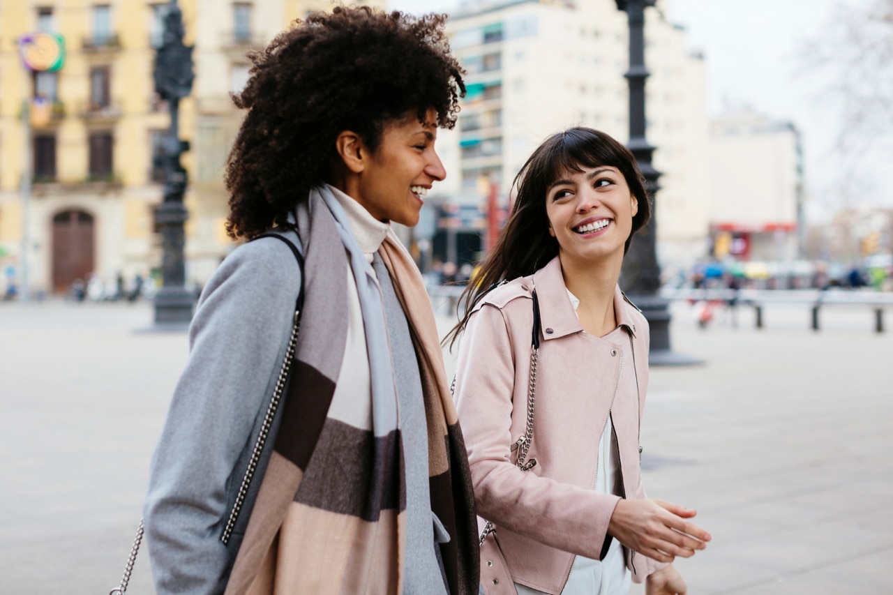 Zwei Frauen unterhalten sich beim Gehen in Barcelona.