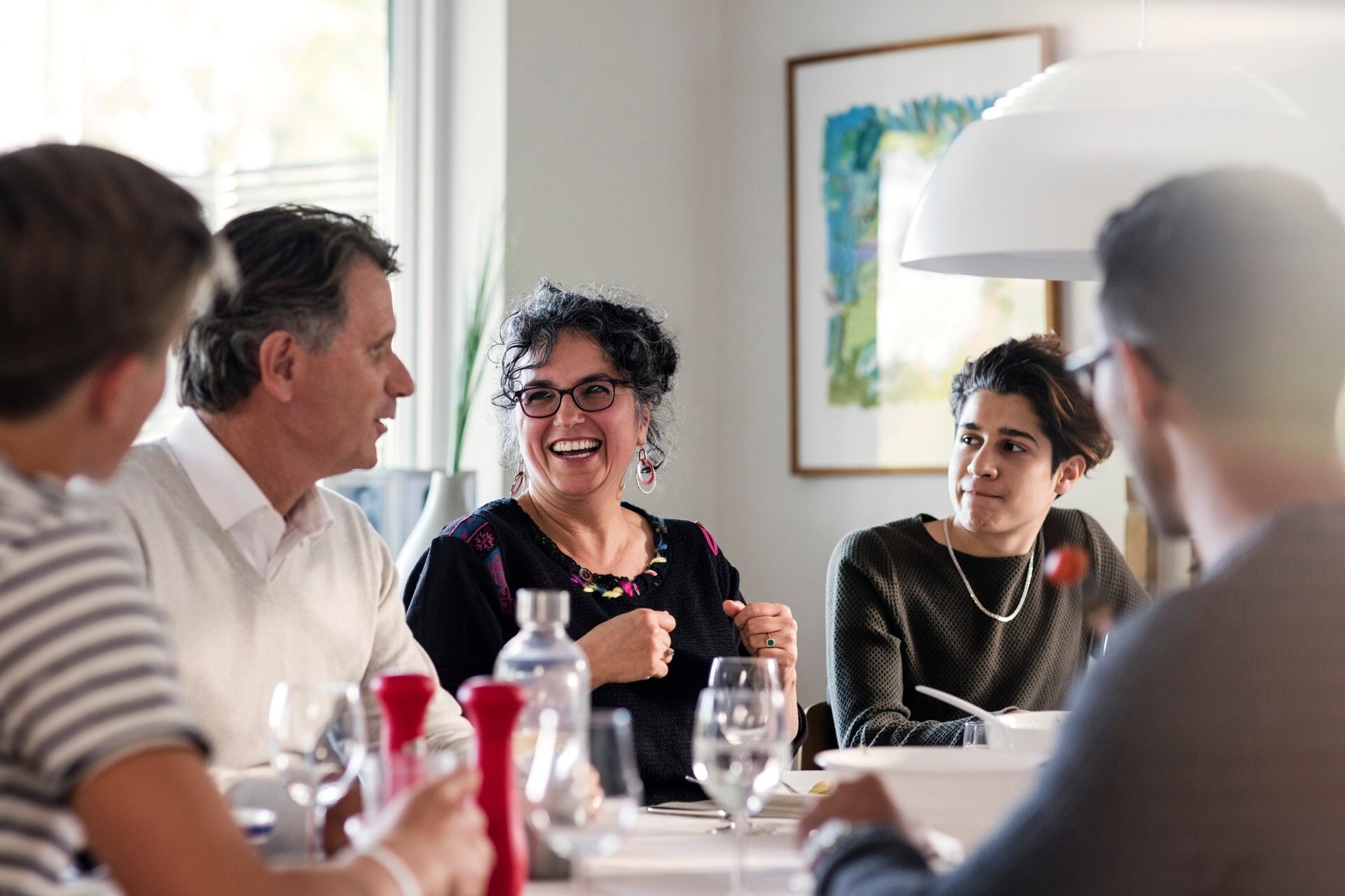 Freunde diskutieren fröhlich beim Abendessen auf einer Dinnerparty