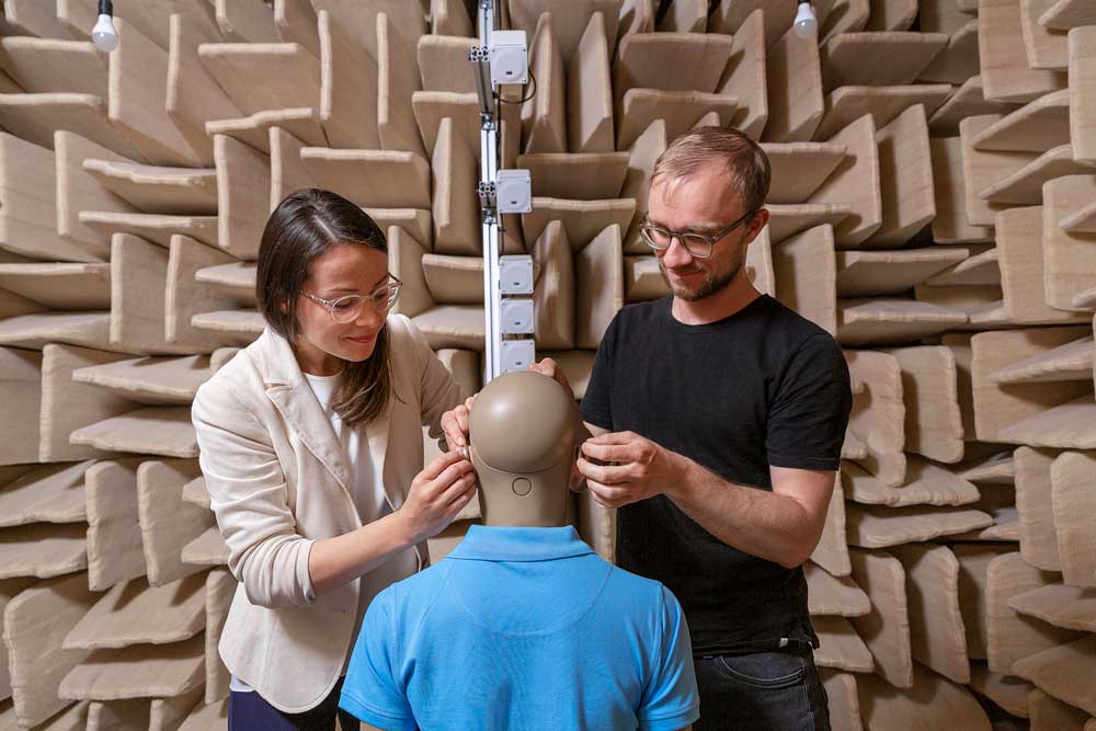 Audiologists placing hearing aids on Kemar