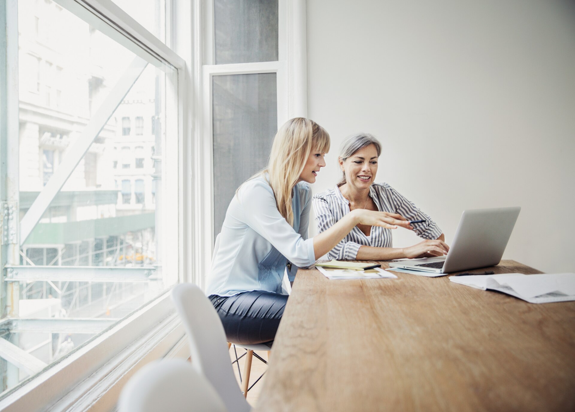 Two female coworkers looking at laptop