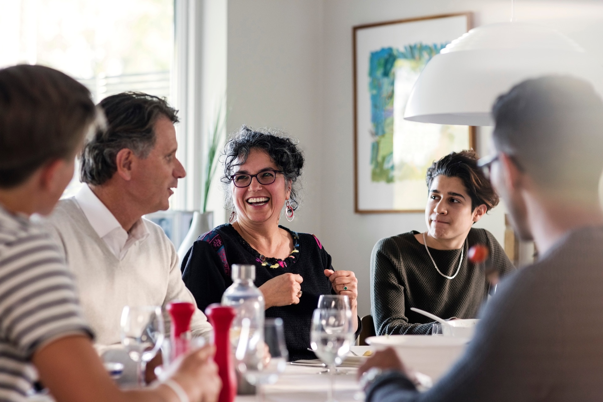 Groupes d’amis joyeux en train de discuter à une table lors d’une fête