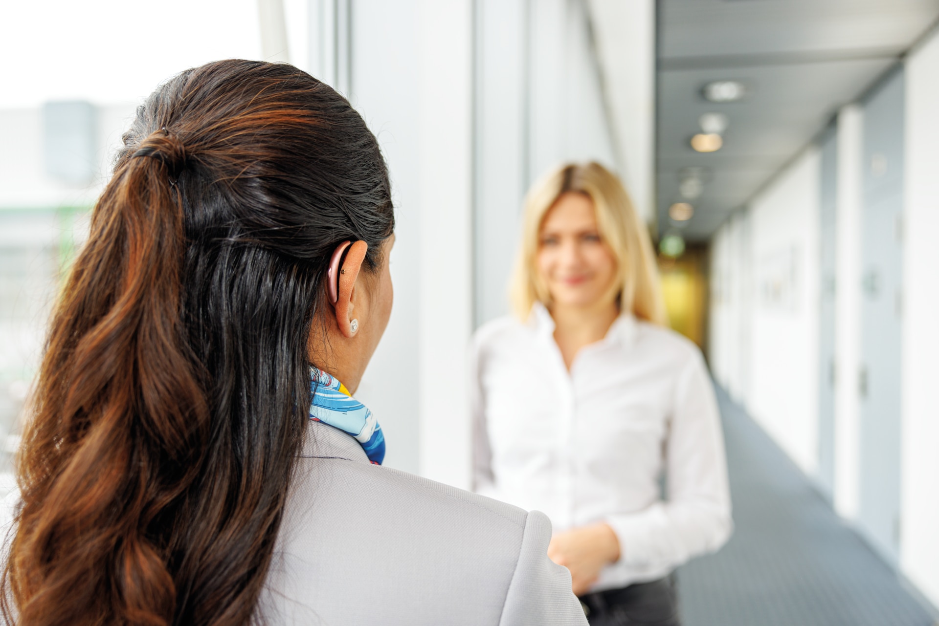 Femme portant une petite aide auditive en train d’avoir une conversation