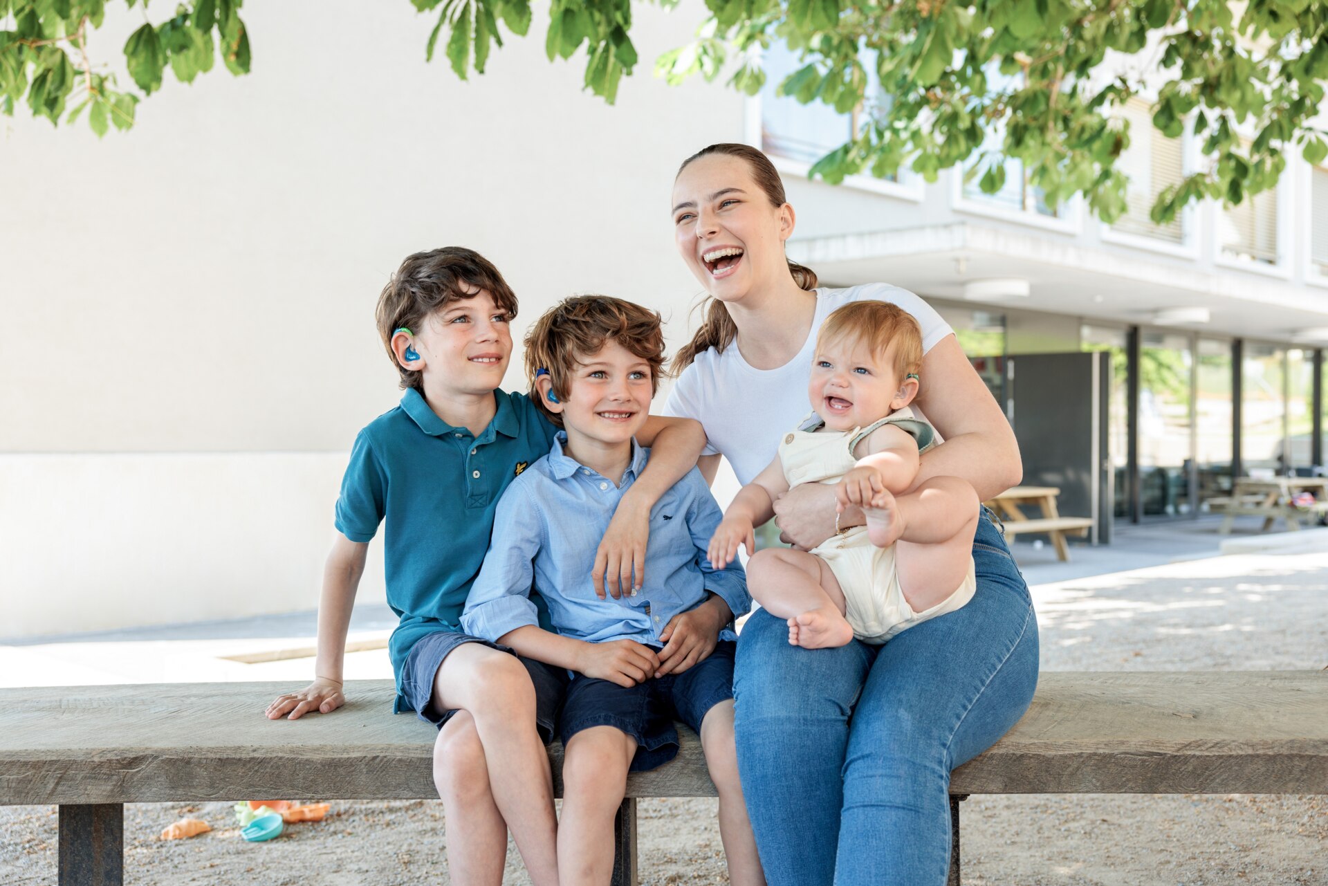 Une mère sur un banc avec ses trois enfants