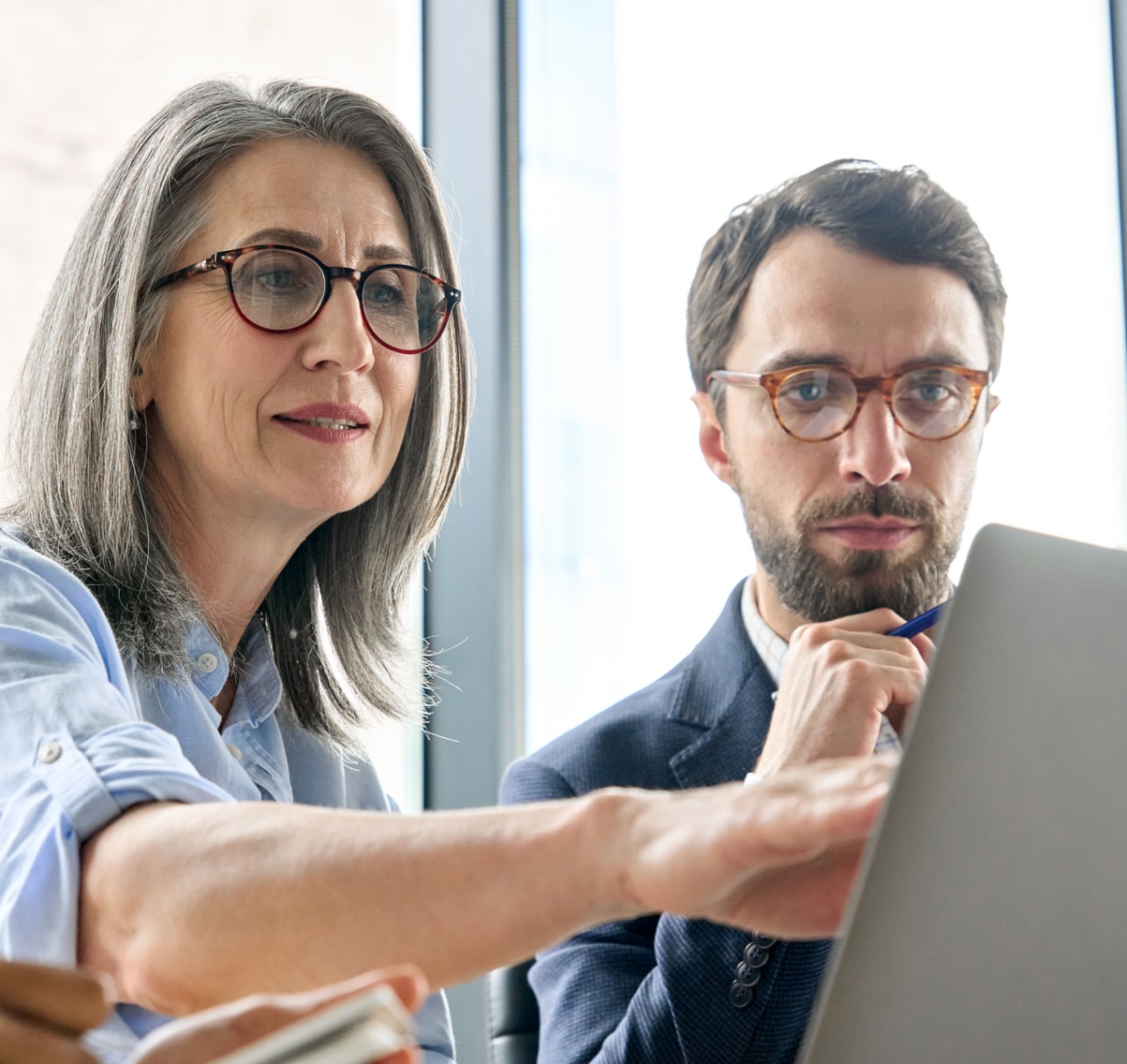 A woman showing something on a laptop screen A woman showing something on a laptop screen
