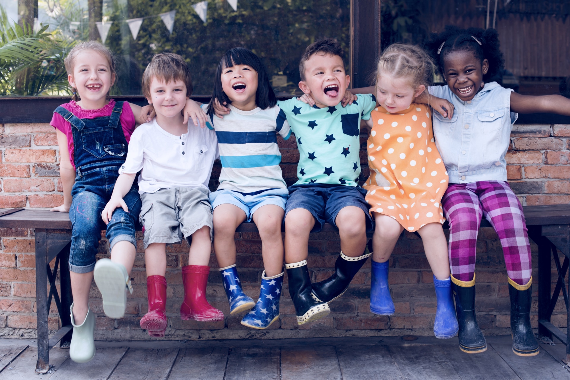 Group of kindergarten kids friends arm around sitting and smiling fun