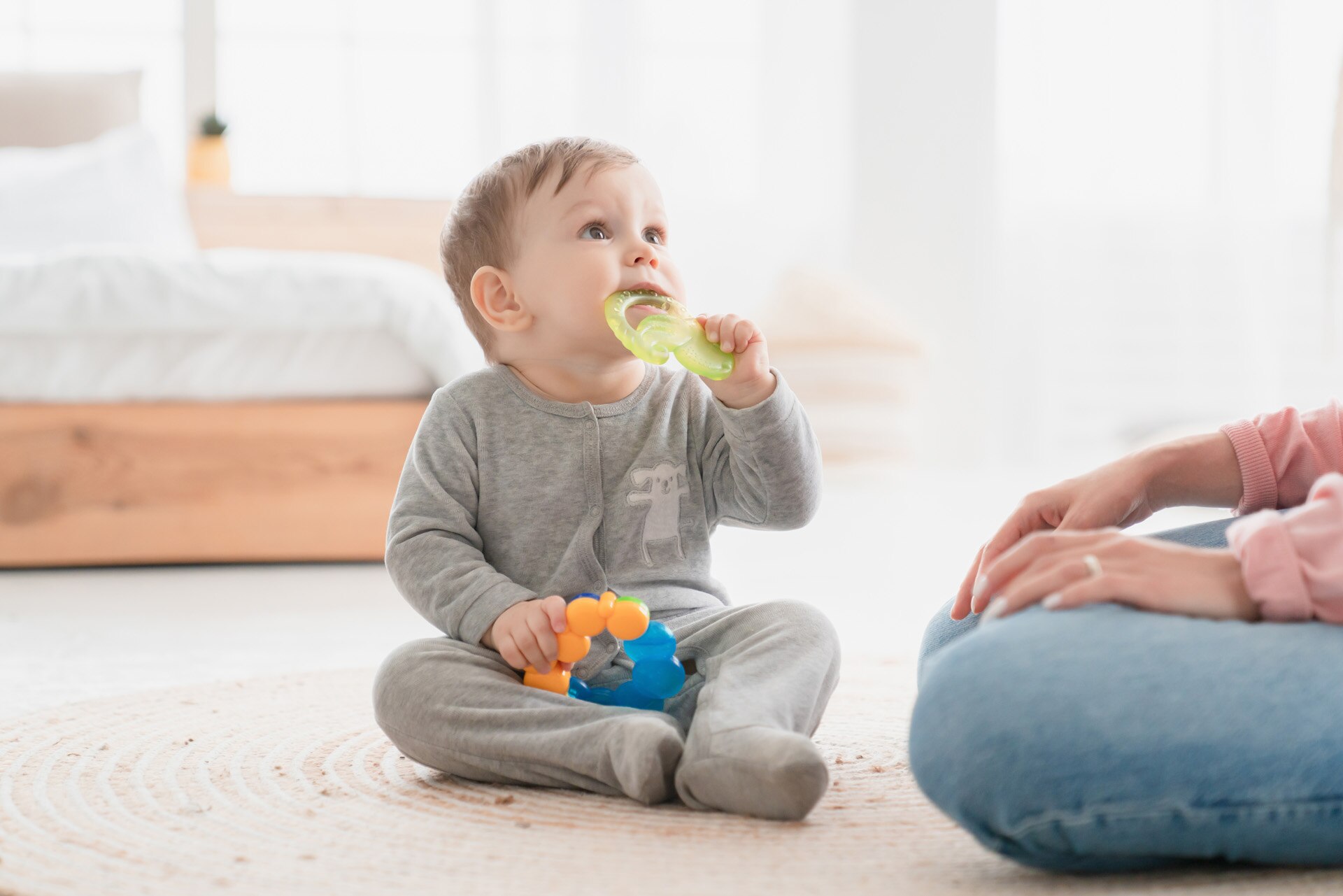 Small little kid child toddler infant newborn baby gnawing toy ring. Teething process, milk baby teeth tooth concept. Playing games with child. Babycare and motherhood; Shutterstock ID 2007312047; purchase_order: -; job: -; client: -; other: -