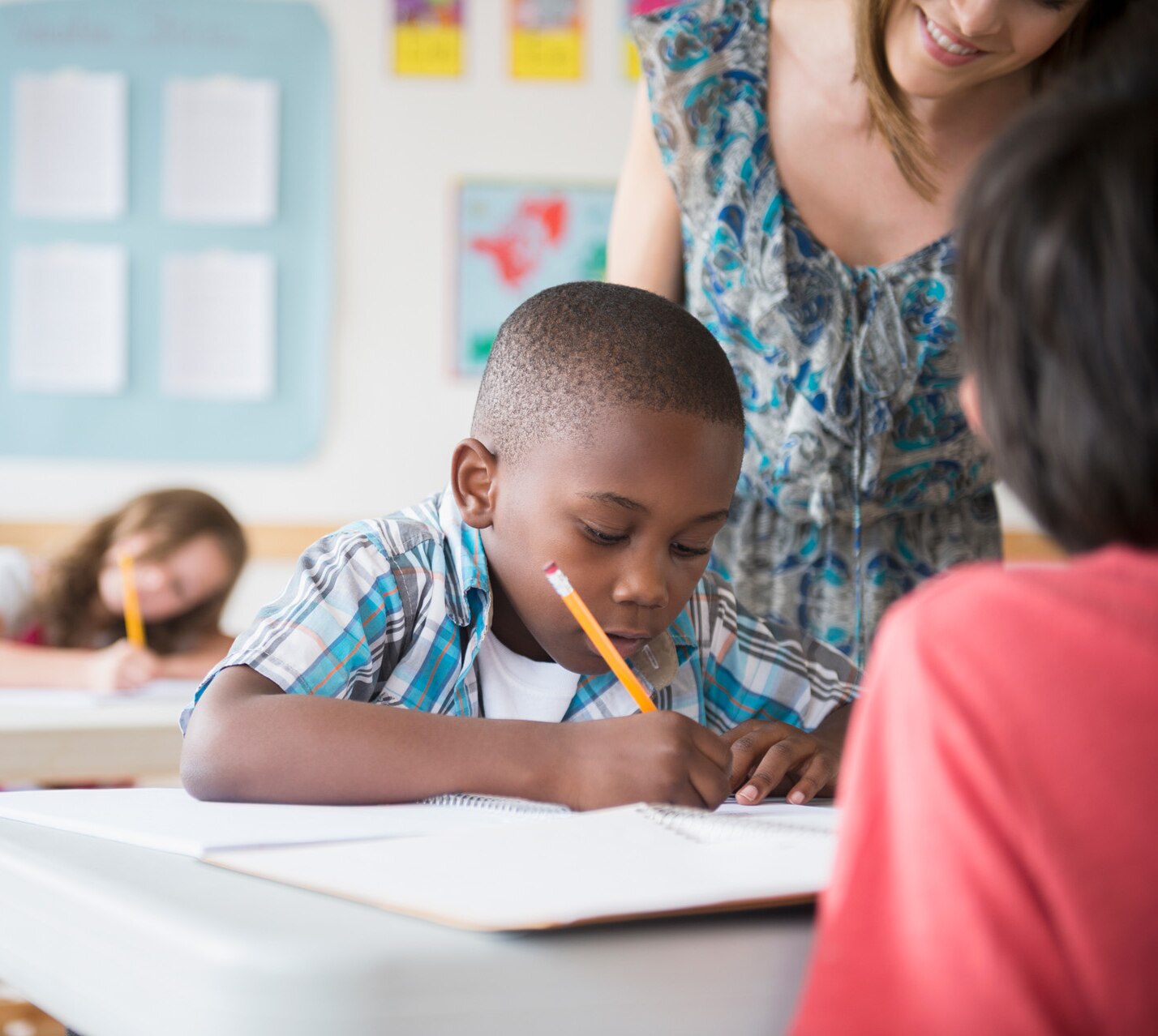 Children (8-9) with female teacher learning in classroom