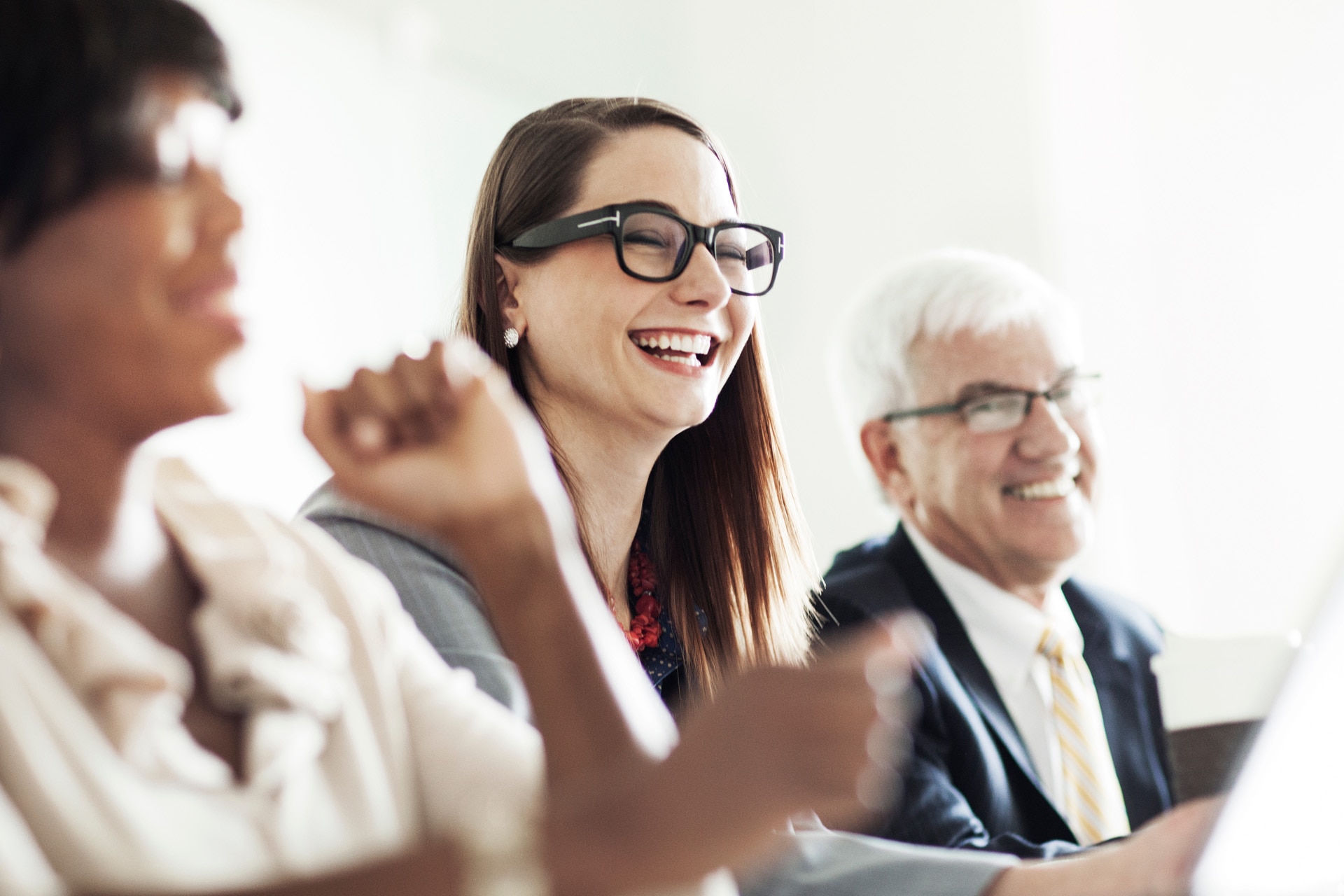 Office workers sharing a laugh during a meeting.