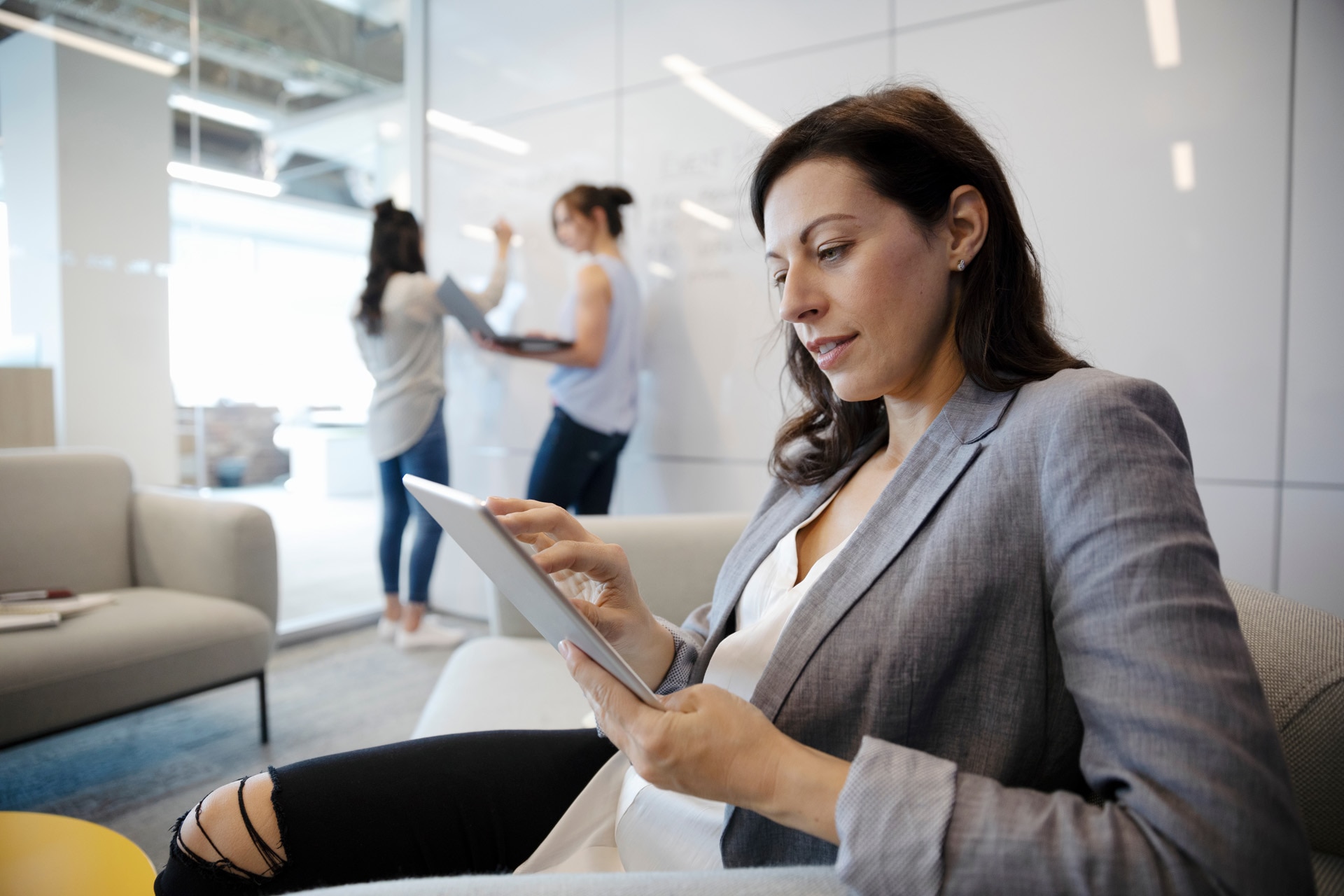 Femme d'affaires utilisant une tablette numérique lors d'une réunion dans une salle de conférence