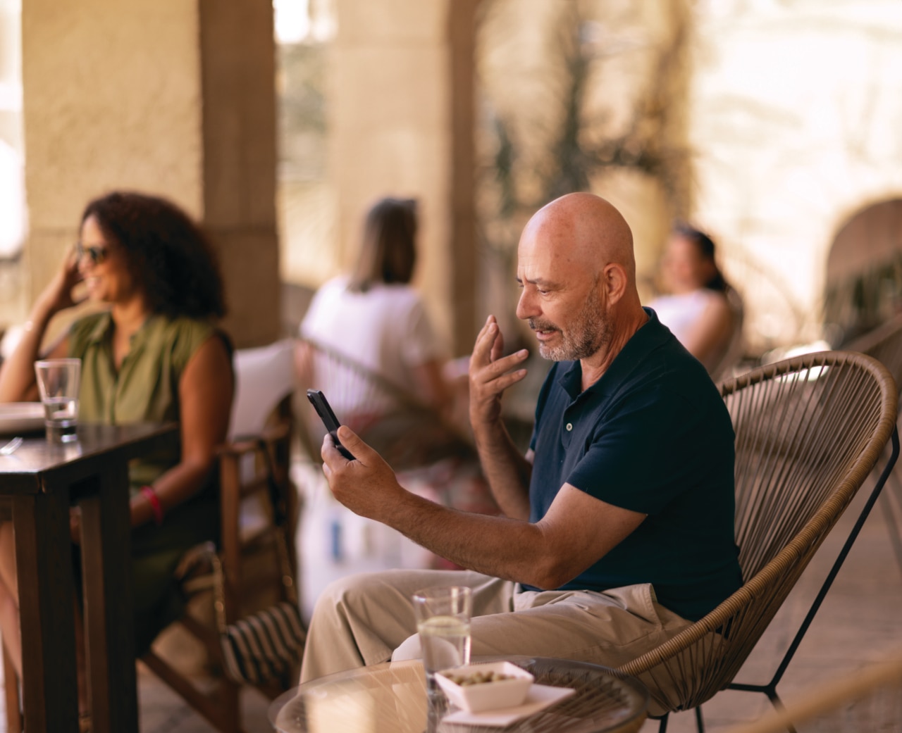 Un homme dans un restaurant en plein air parle au t�l�phone Un homme dans un restaurant
