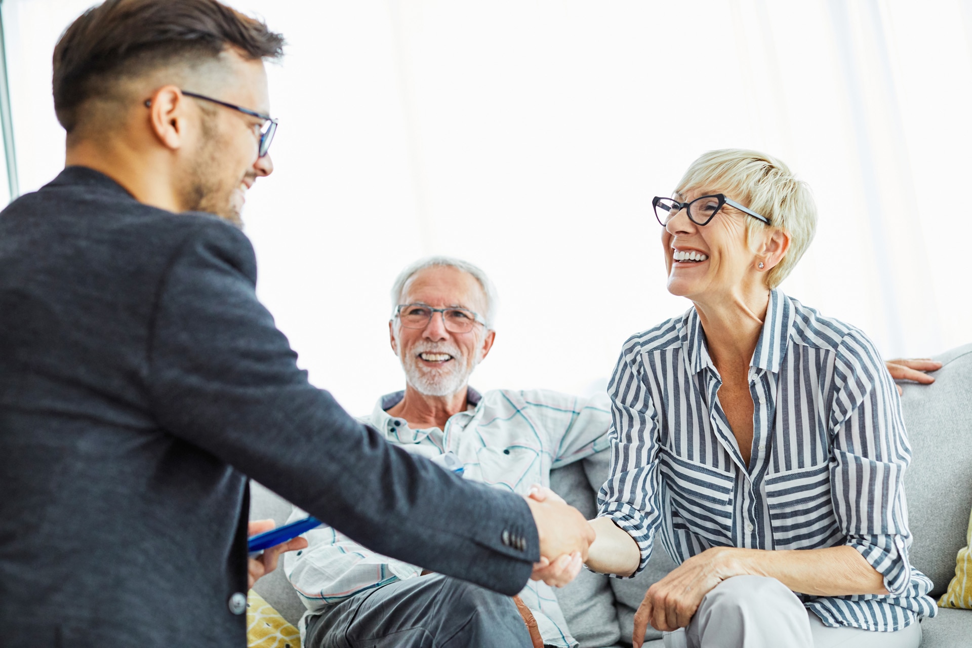 Happy senior old family couple clients make financial insurance estate business deal handshake agent lawyer, satisfied mature customers shake hand meeting bank manager agree on investment contract; Shutterstock ID 1801300663; purchase_order: -; job: -; client: -; other: -