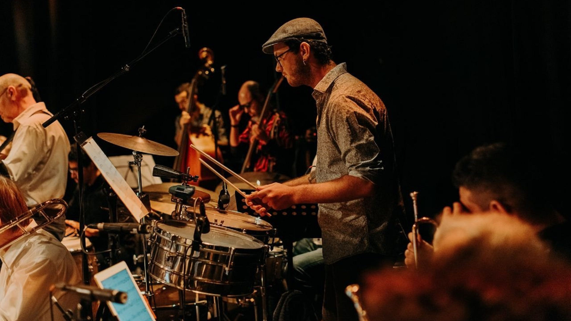 Henri, musicien professionnel et professeur de musique jouant de la guitare électrique chez lui.