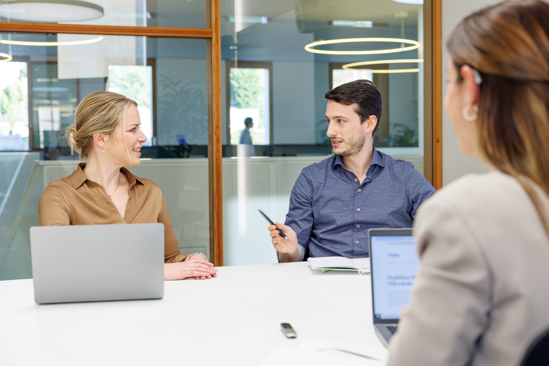 Un des hommes participant à une conversation professionnelle porte un dispositif Phonak Roger On fixé sur sa veste.