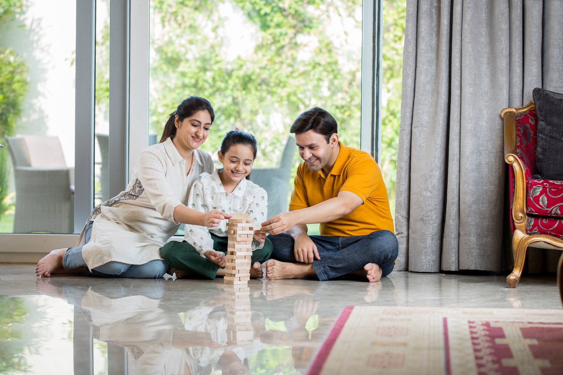 Happy Family sitting On floor Playing With The Wooden Blocks At Home; Shutterstock ID 1887473806; purchase_order: -; job: -; client: -; other: -