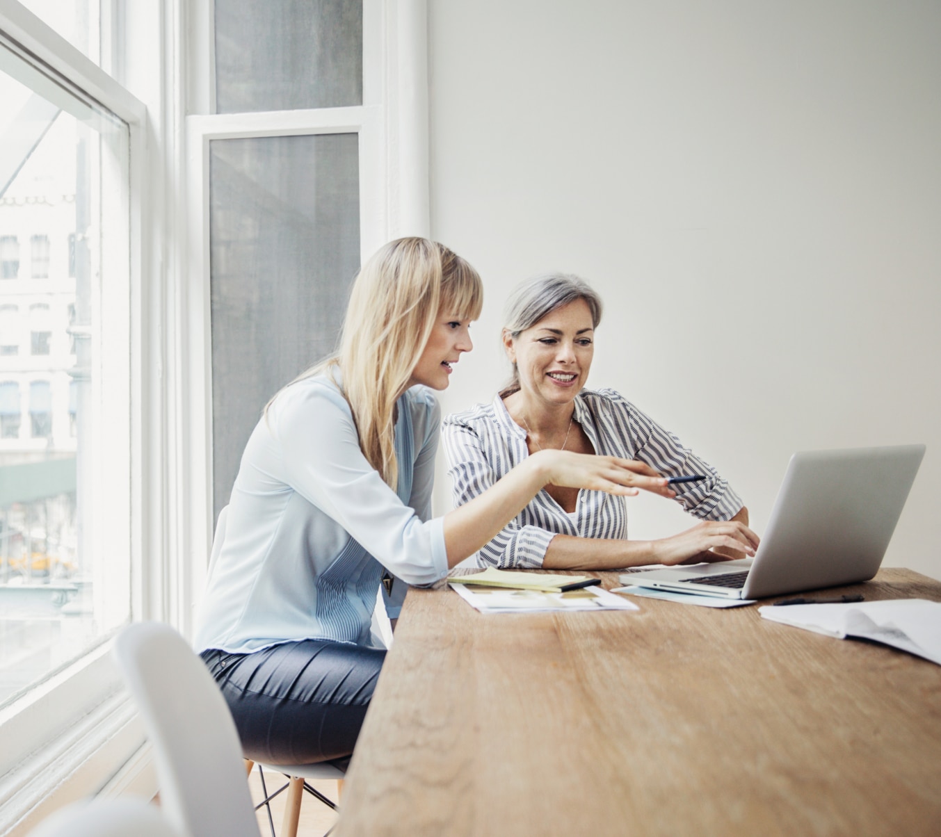 Two female coworkers looking at laptop