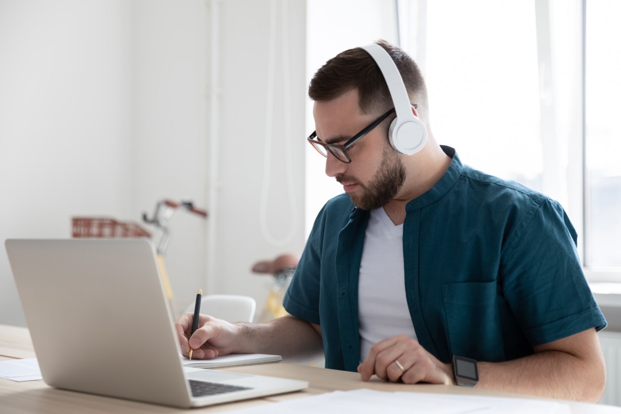 Konzentrierter junger Gesch�ftsmann, Firmenangestellter mit Brille und kabellosen Kopfh�rern Focused young man businessman company worker employee in glasses wearing wireless headphones
