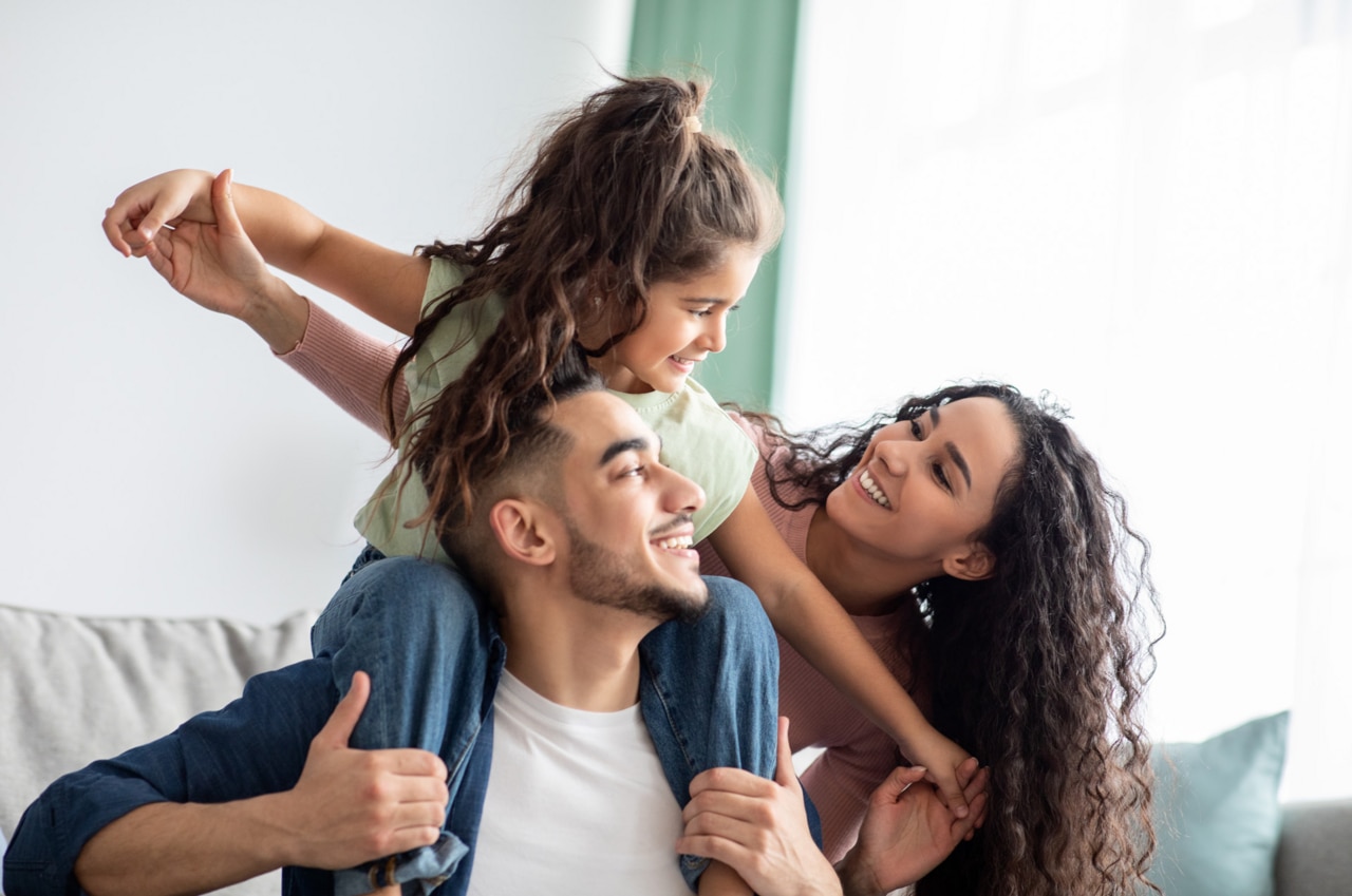 Cheerful Middle Eastern Family Of Three Having Fun Together At Home; Shutterstock ID 1936256839; purchase_order: -; job: -; client: -; other: -