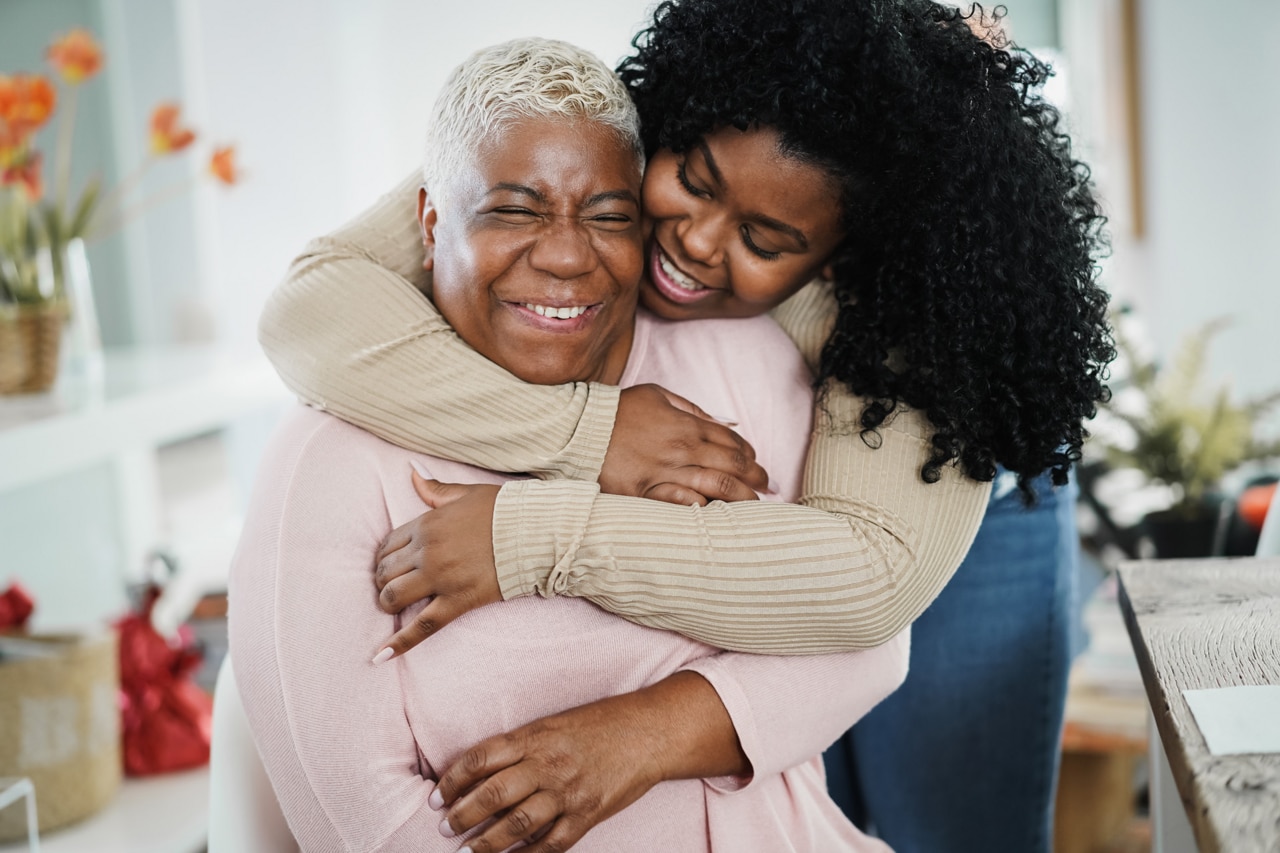 African daughter hugging her mum indoors at home - Main focus on senior woman face; Shutterstock ID 1963184836; purchase_order: -; job: -; client: -; other: -
