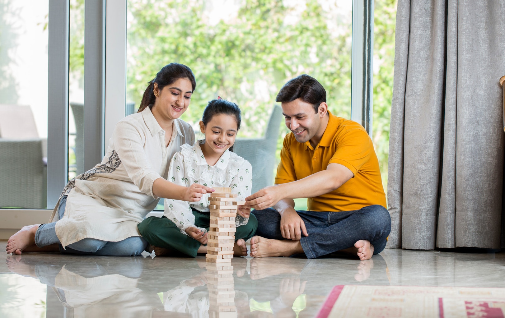 Happy Family sitting On floor Playing With The Wooden Blocks At Home; Shutterstock ID 1887473806; purchase_order: -; job: -; client: -; other: -