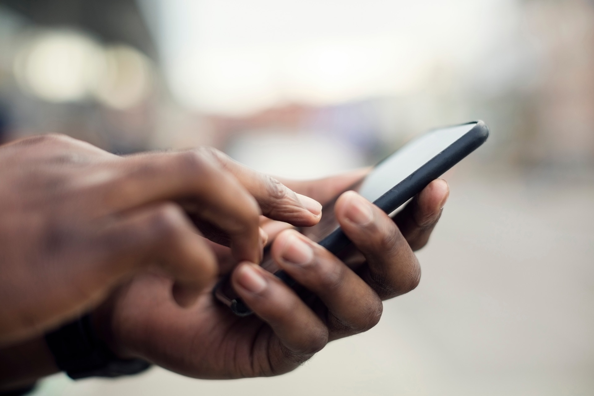 Primer plano de las manos sosteniendo un teléfono inteligente.