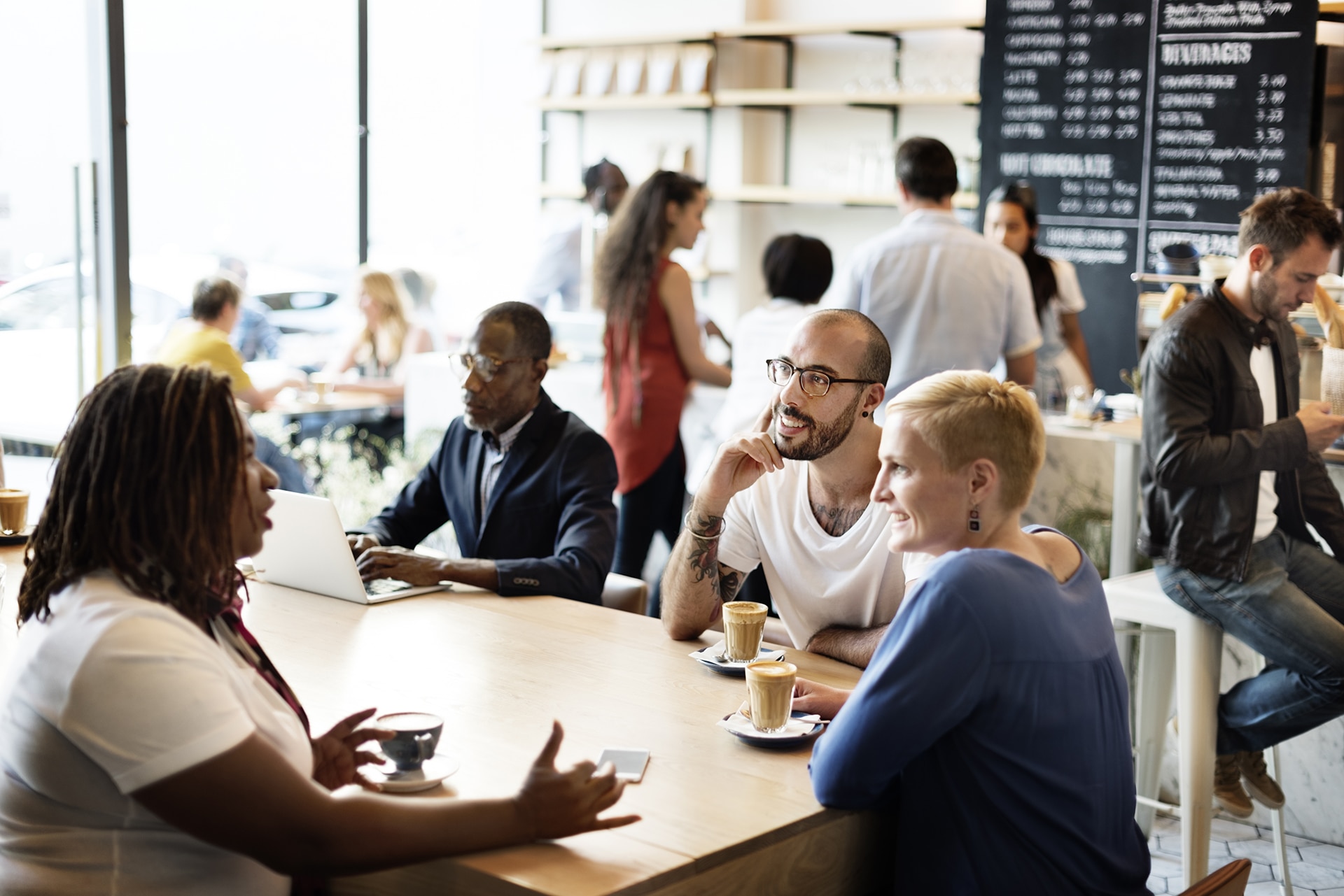 Concepto de lluvia de ideas de unos amigos con diversidad en una reunión en una cafetería