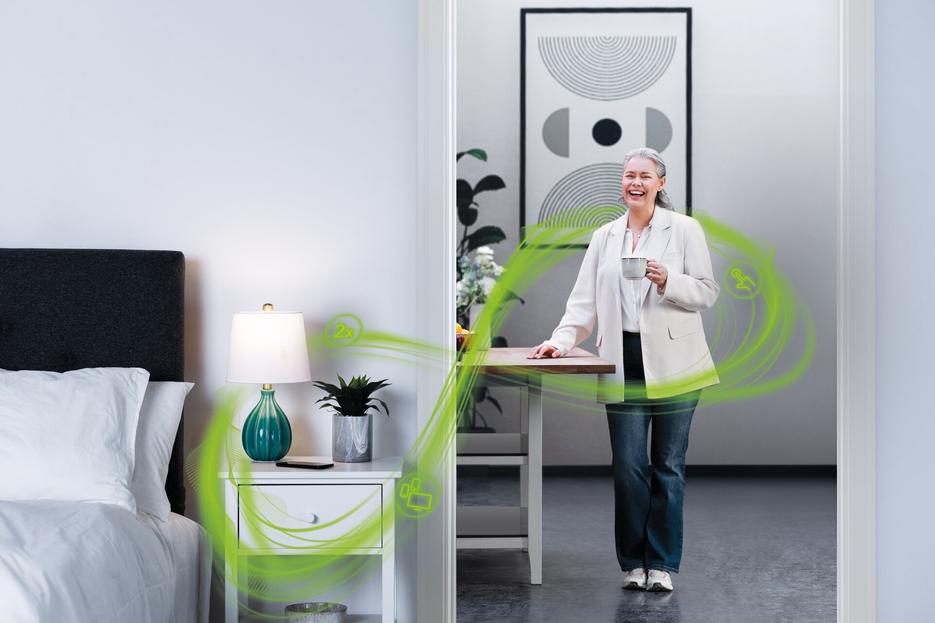 Una mujer madura en la puerta de la habitación, con una taza de café en la mano y sonriendo. Está rodeada por un símbolo de infinito verde, símbolo de la tecnología Phonak Infinio.