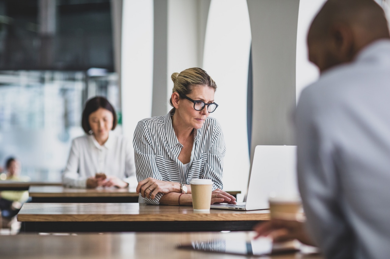 Femme d'affaires dans un café utilisant un ordinateur portable Femme d'affaires dans un café utilisant un ordinateur portable