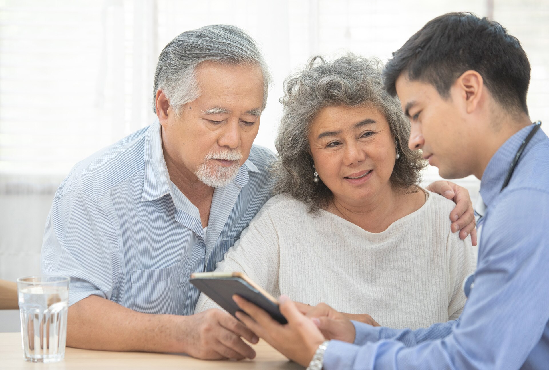 Elder senior old asian couple meeting  specialist professional caucasian doctor visit at home consultant two retirement patient after checkup,health care and medical concept