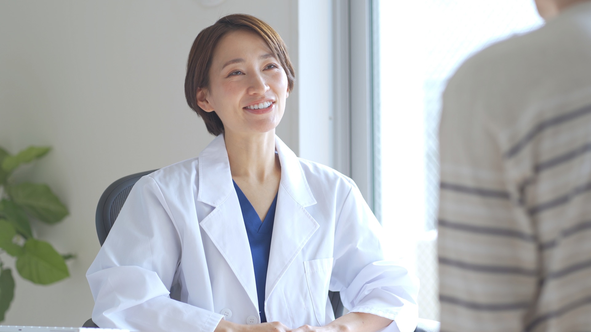 Nőnemű japán egészségügyi dolgozó beteget vizsgál.