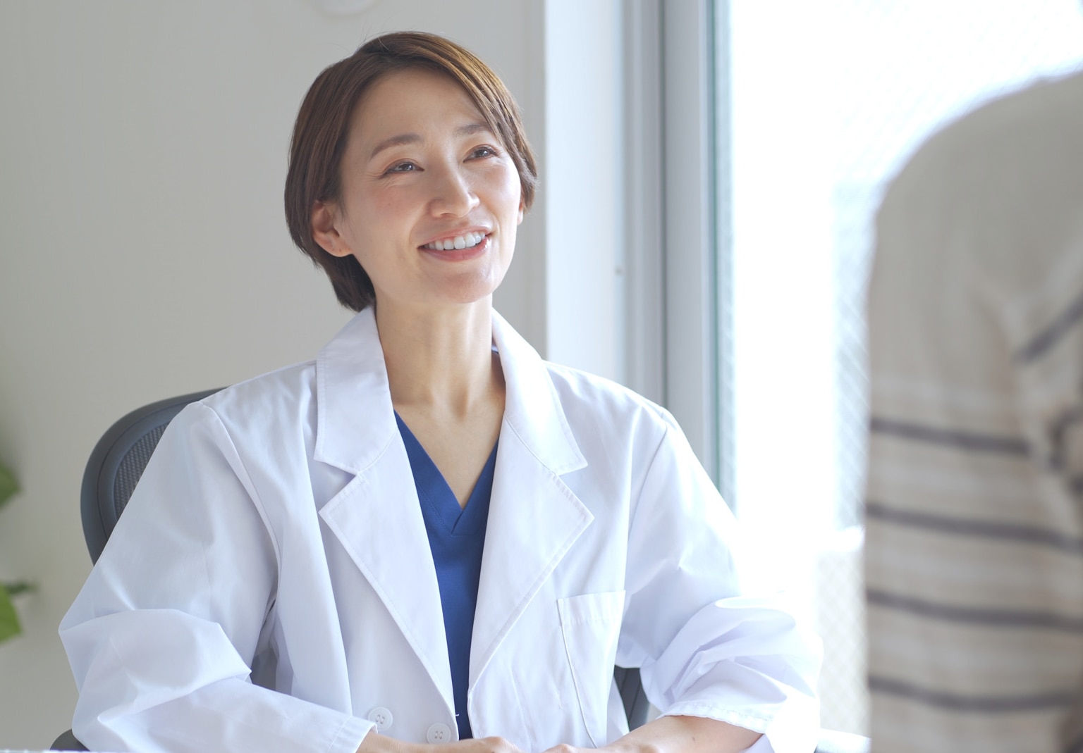 Nőnemű japán egészségügyi dolgozó beteget vizsgál.
