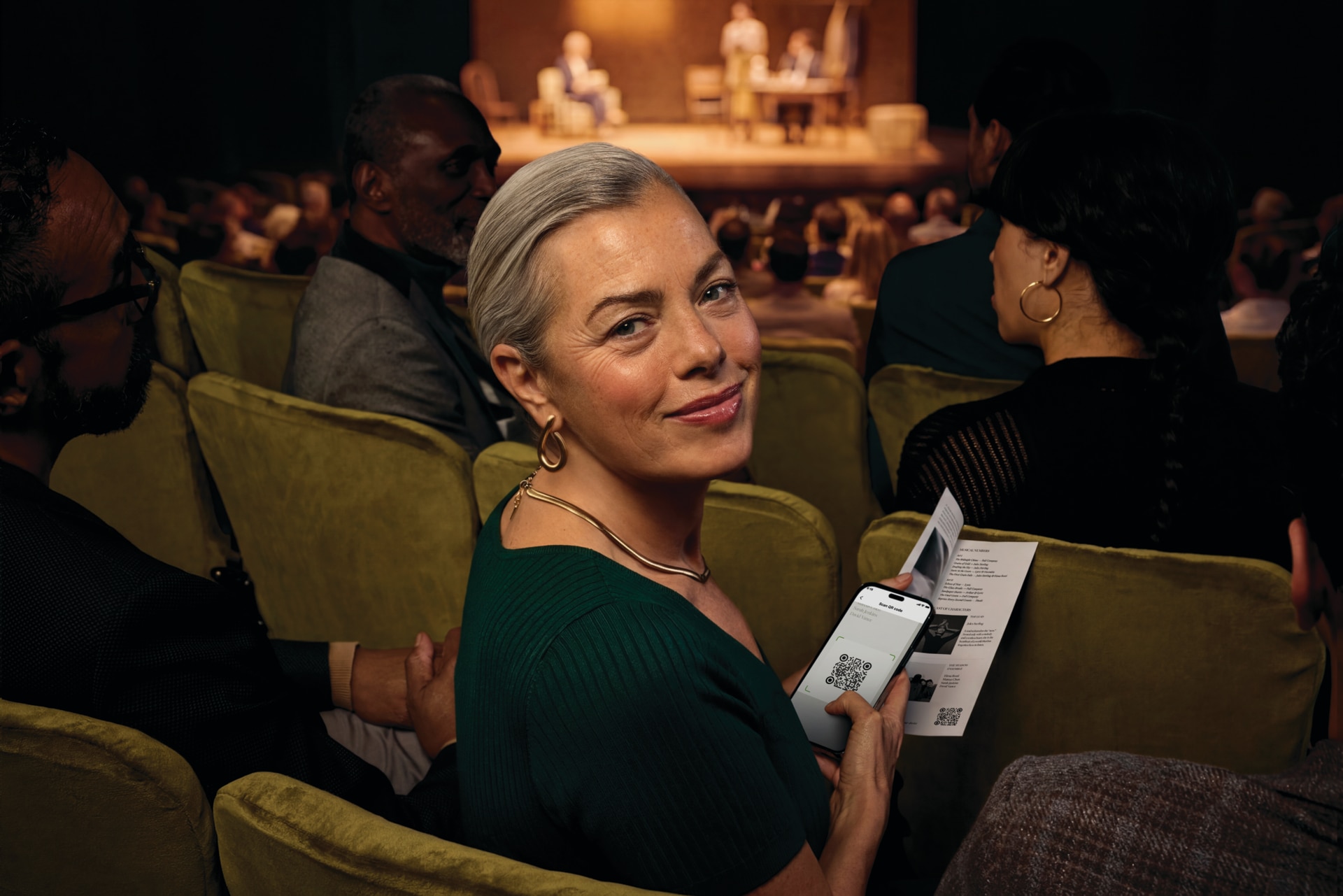 Person using Phonak Audéo™ EON   hearing aids in a theater with Auracast.