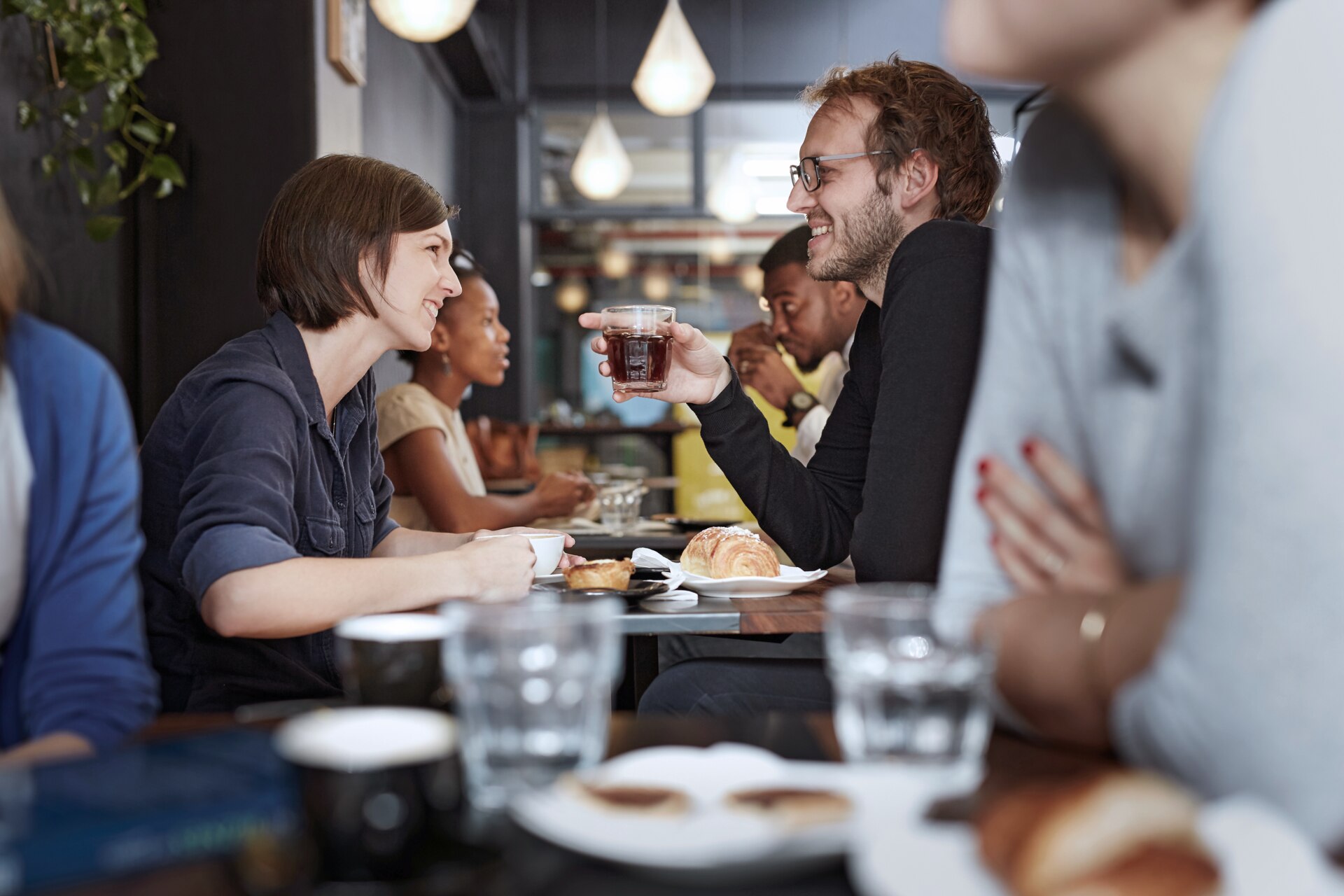 Female and male friends having a chat in a crowded bistro.