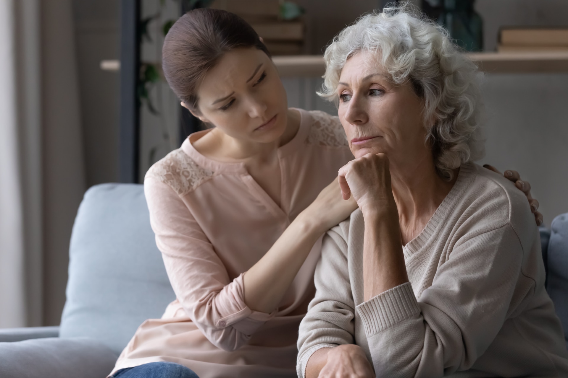 Young female caregiver support grieving suffering mature old woman retiree express empathy compassion.