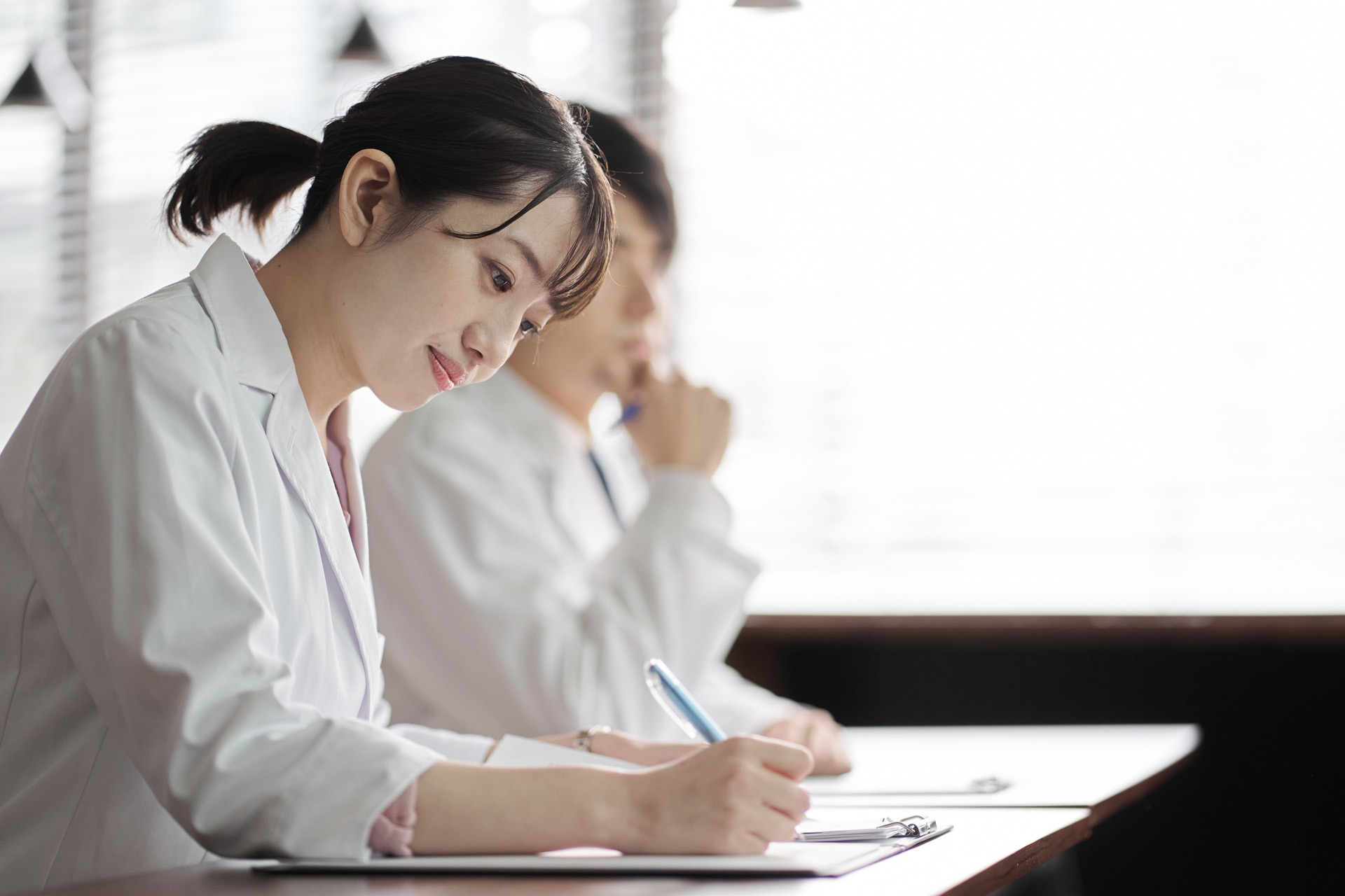 Japanese female medical worker examining a patientAsian medical personnel attending the seminar