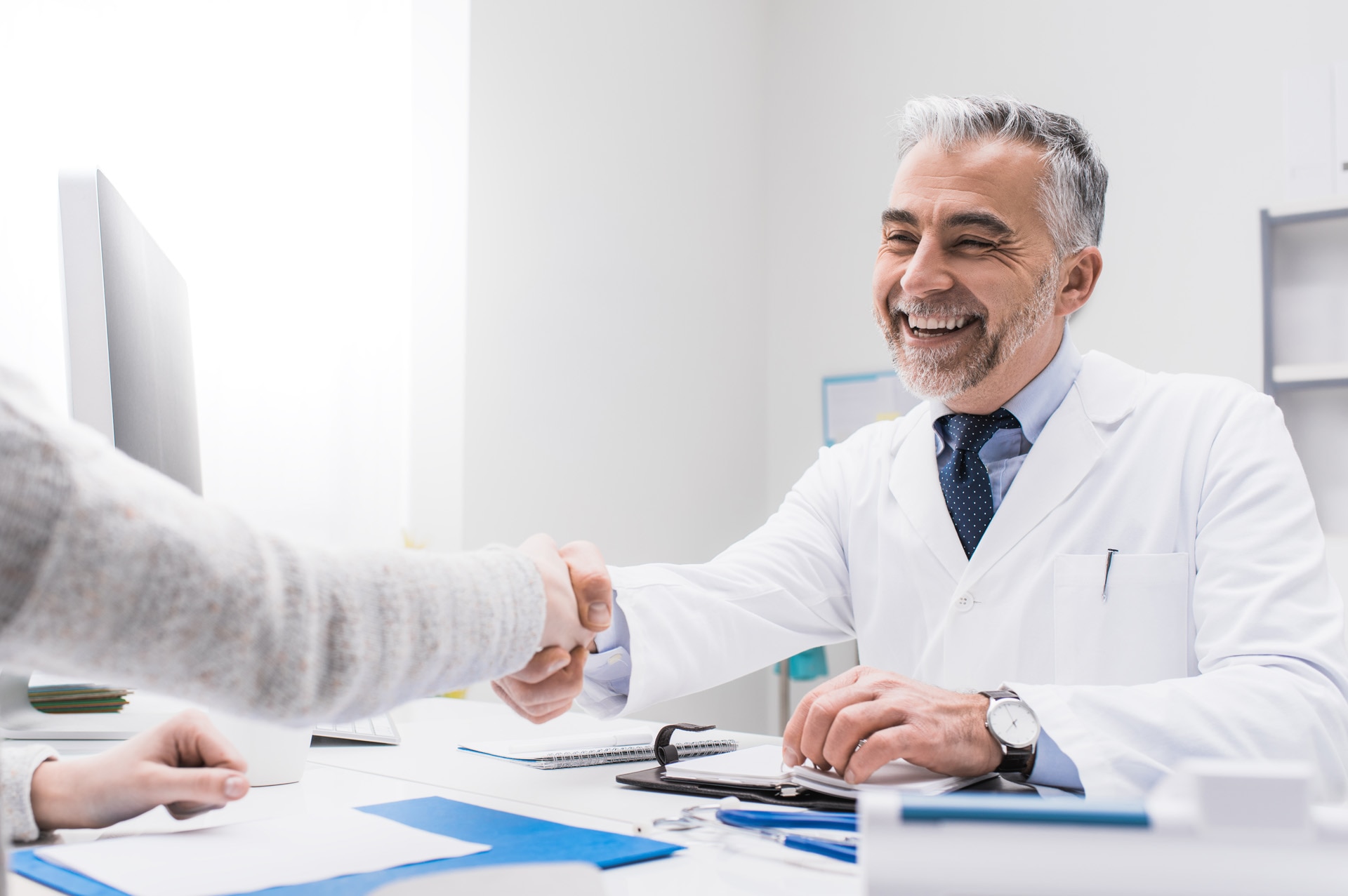 Medico sorridente che stringe la mano al paziente