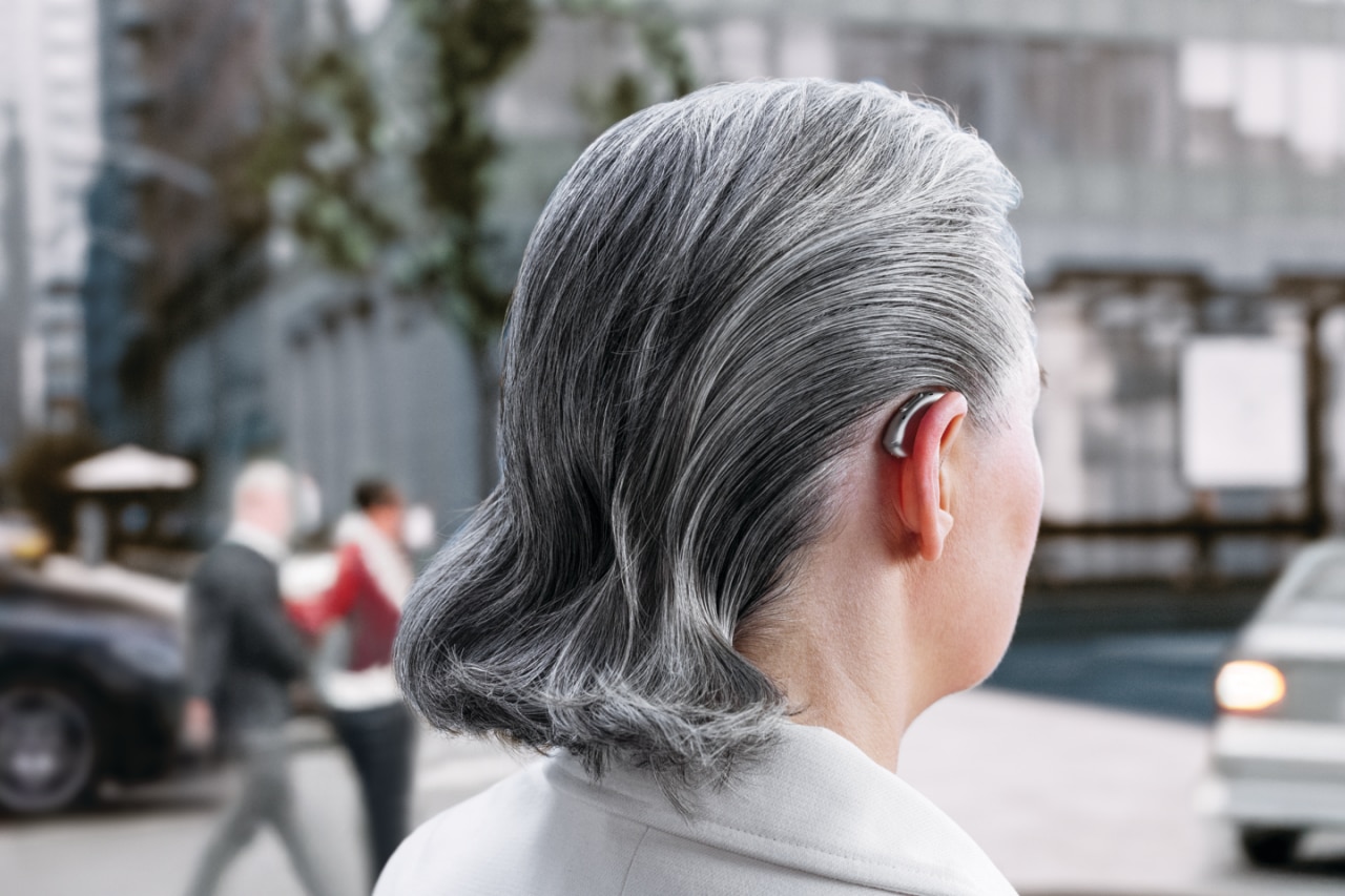 산에서 큰 돌에 앉아 바다를 바라보는 여성 관광객.