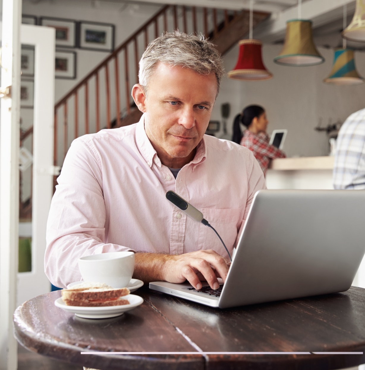 Hombre de mediana edad usando un portátil en una cafetería