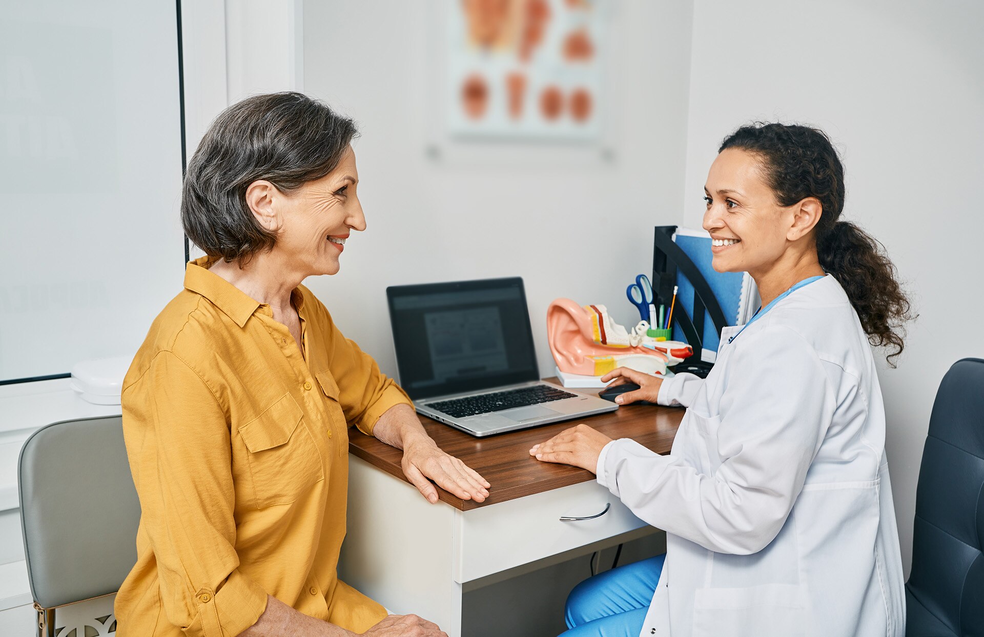 Hearing test to mature woman. Senior woman during hearing test and audiometry at hearing clinic with audiologist. Side view; Shutterstock ID 2009901761; purchase_order: -; job: -; client: -; other: -