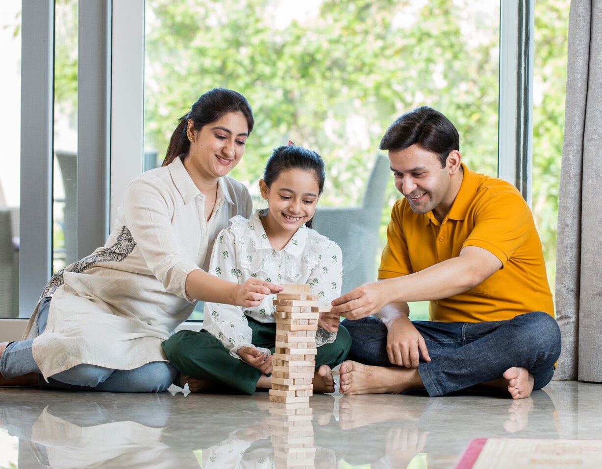 Happy Family sitting On floor Playing With The Wooden Blocks At Home; Shutterstock ID 1887473806; purchase_order: -; job: -; client: -; other: -