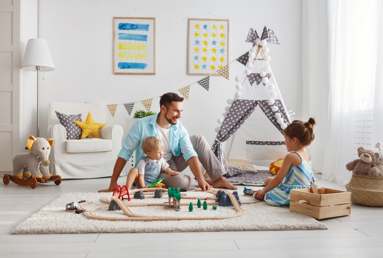 family father and children play a toy railway in the playroom
; Shutterstock ID 1033143271; purchase_order: -; job: -; client: -; other: -