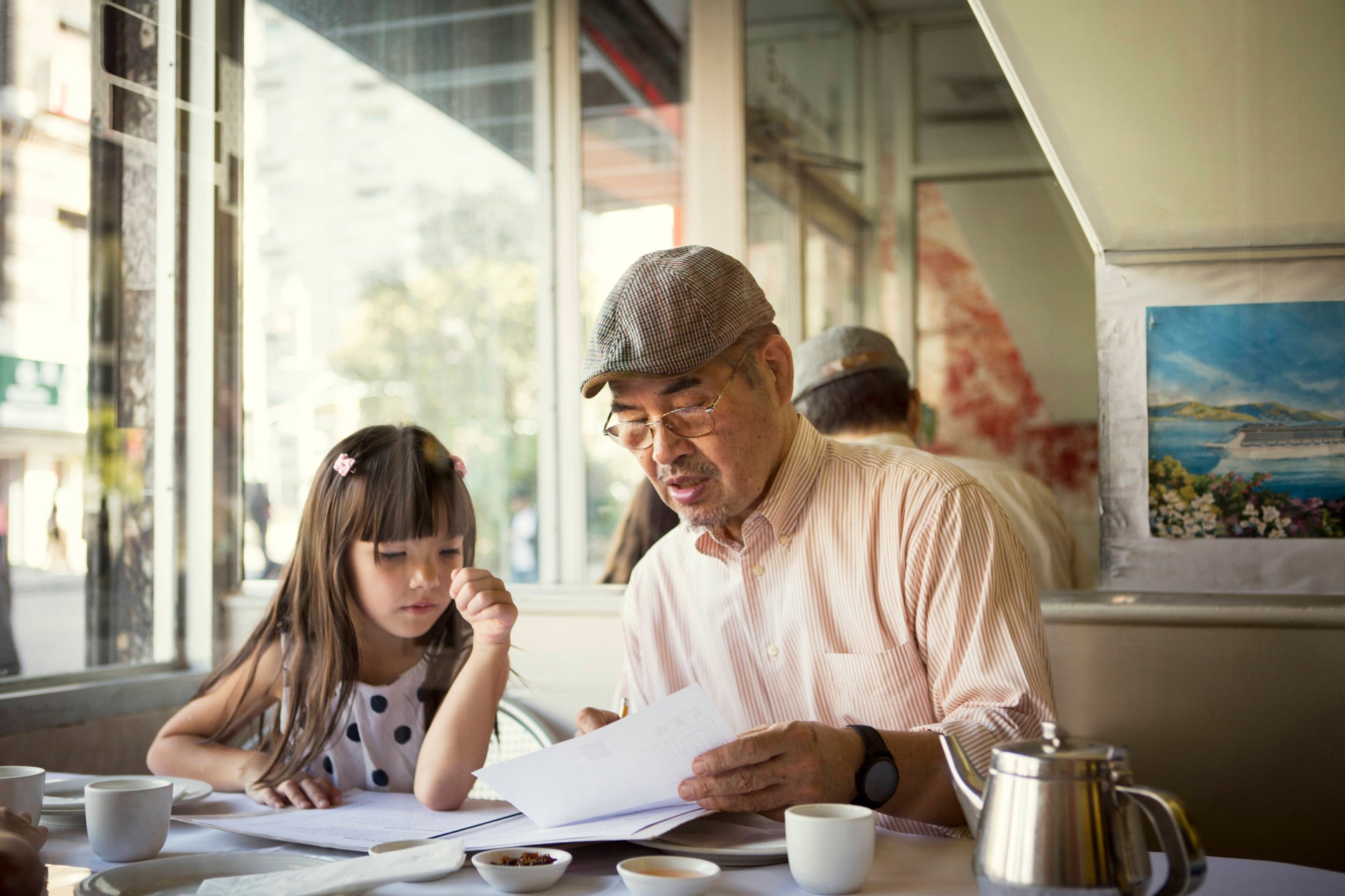 Man showing girl paper in restaurant