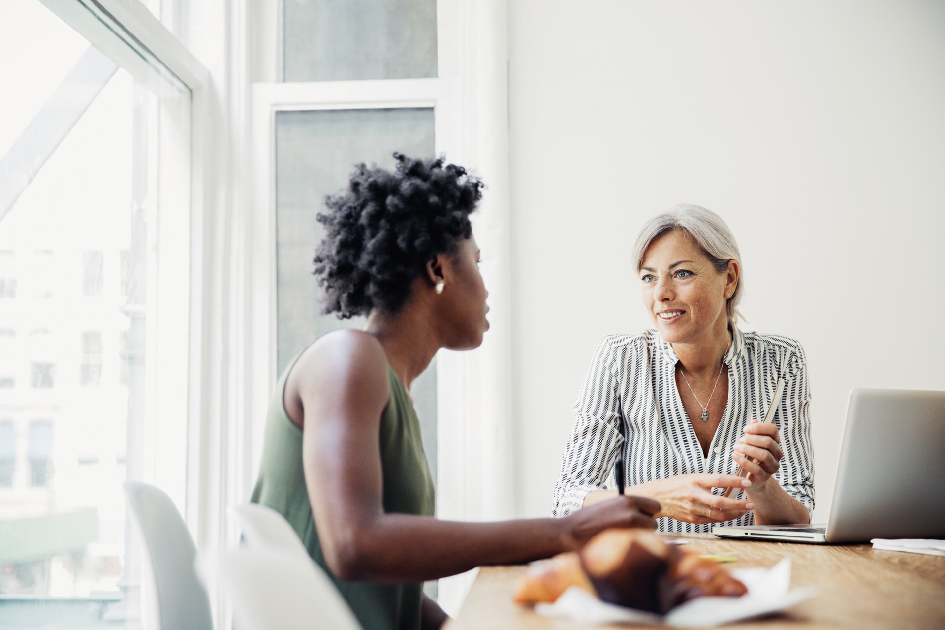 Two women having a discussion at a conference table