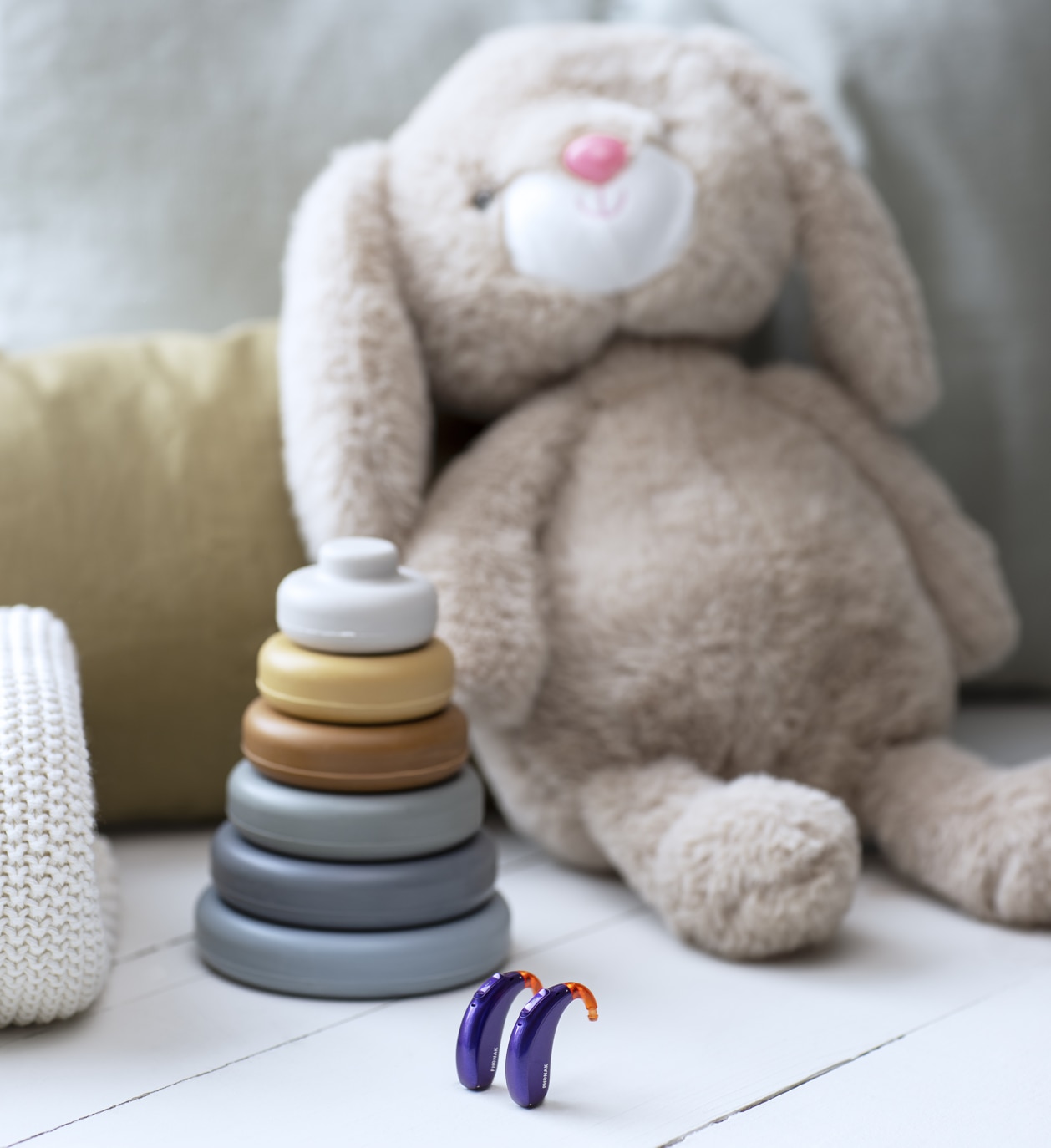 Hearing aids near stuffed animal and baby toy