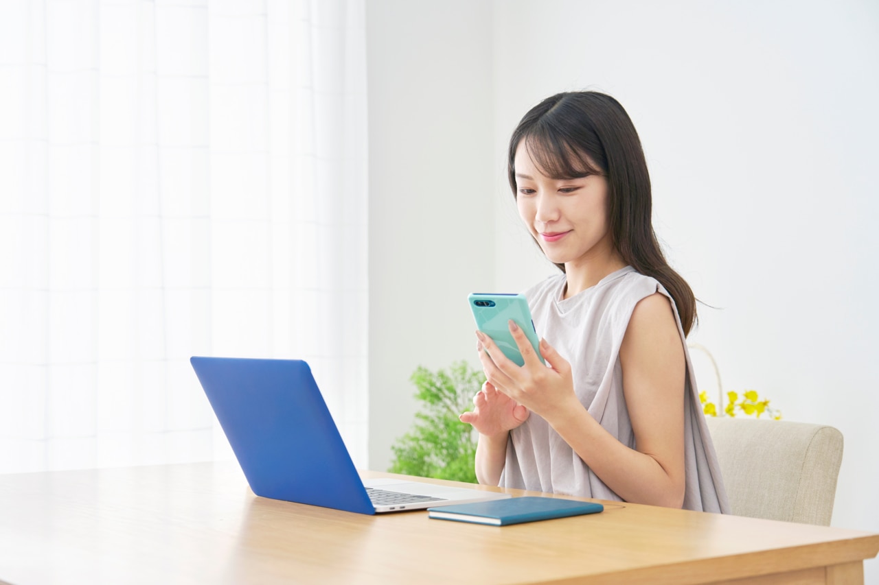 2086945747 Asian woman using the smartphone at home; Shutterstock ID 2086945747; purchase_order: -; job: -; client: -; other: -
