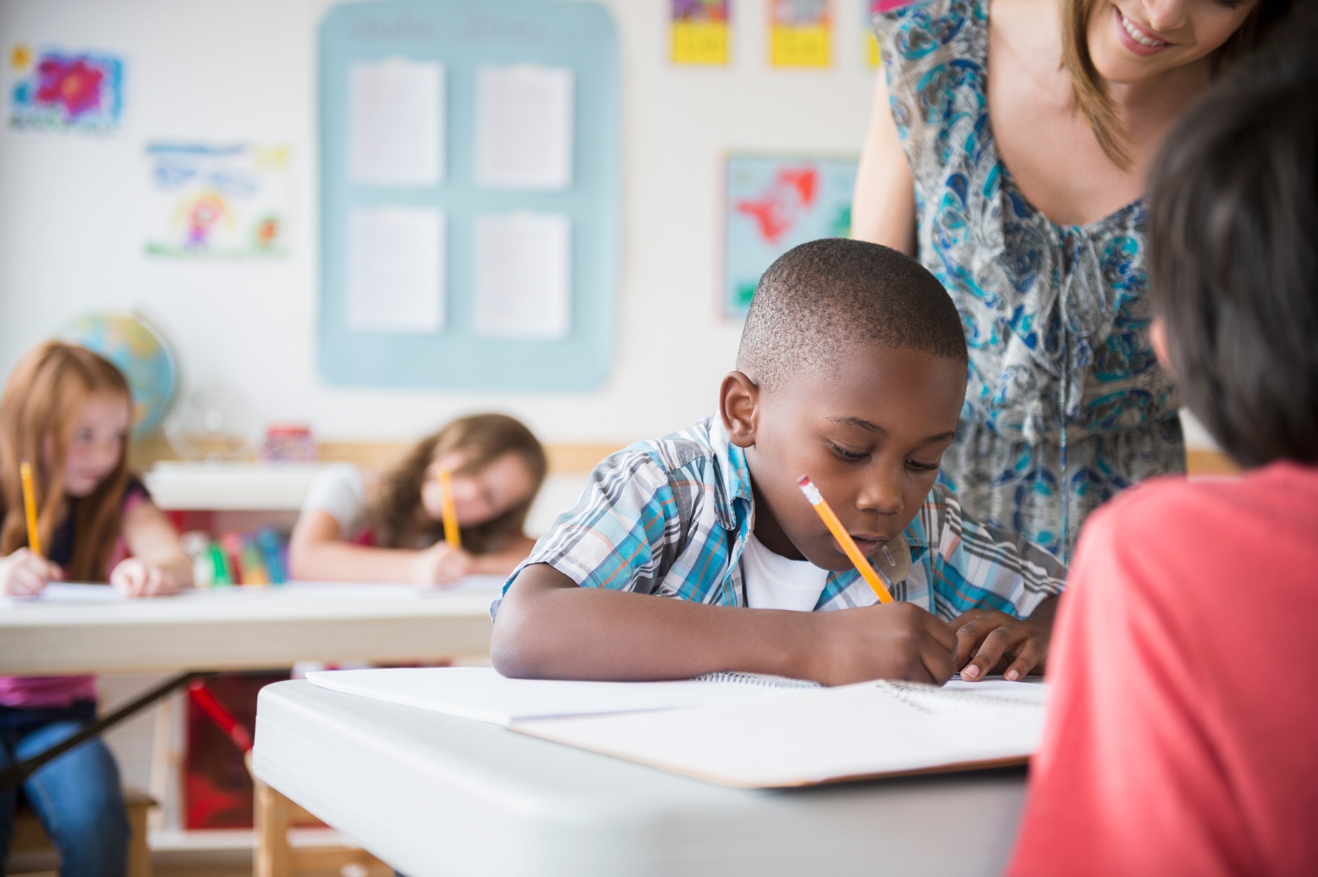 Children (8-9) with female teacher learning in classroom