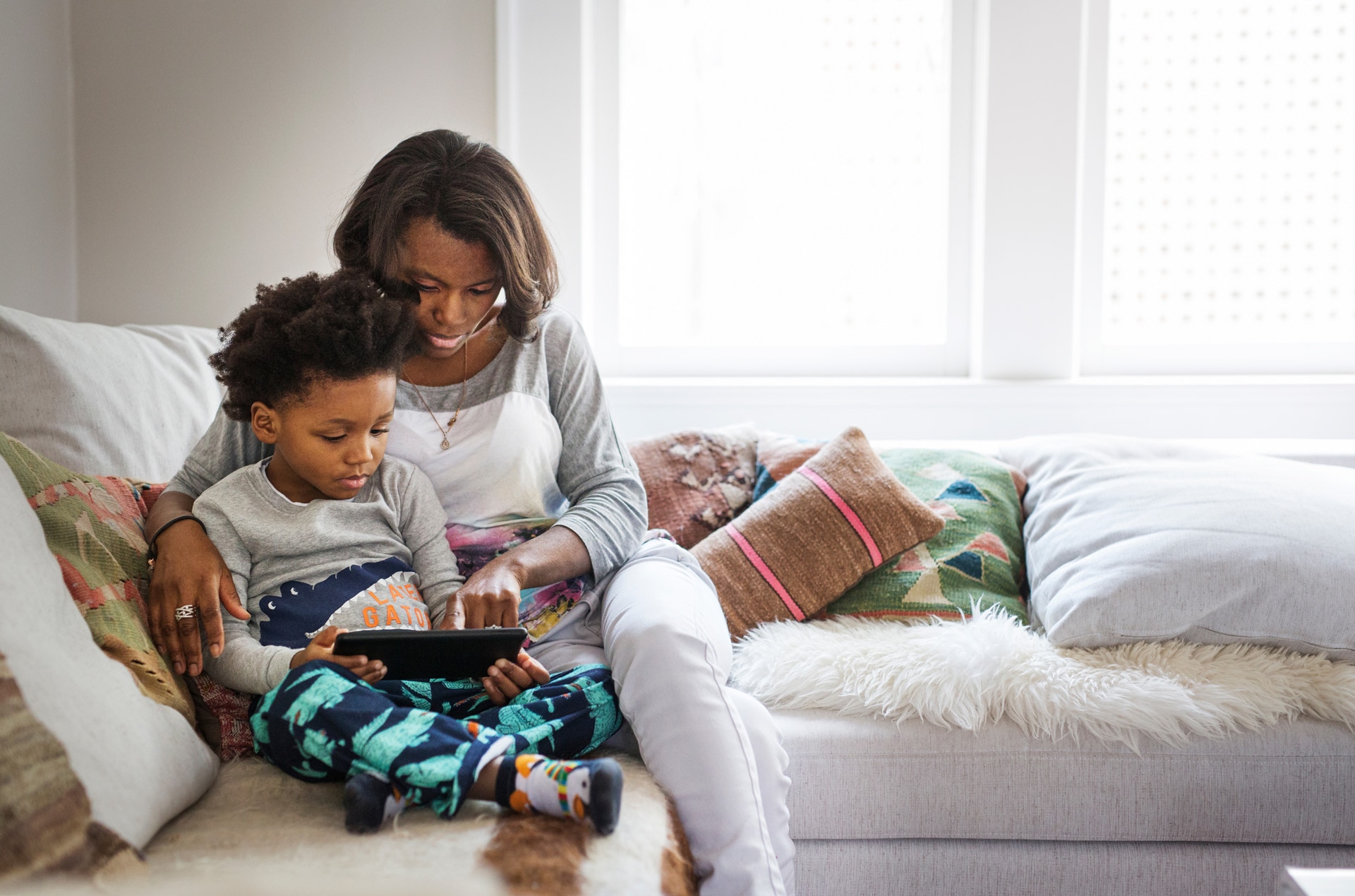 Mother and son playing on a tablet together. Mother and son playing on a tablet together