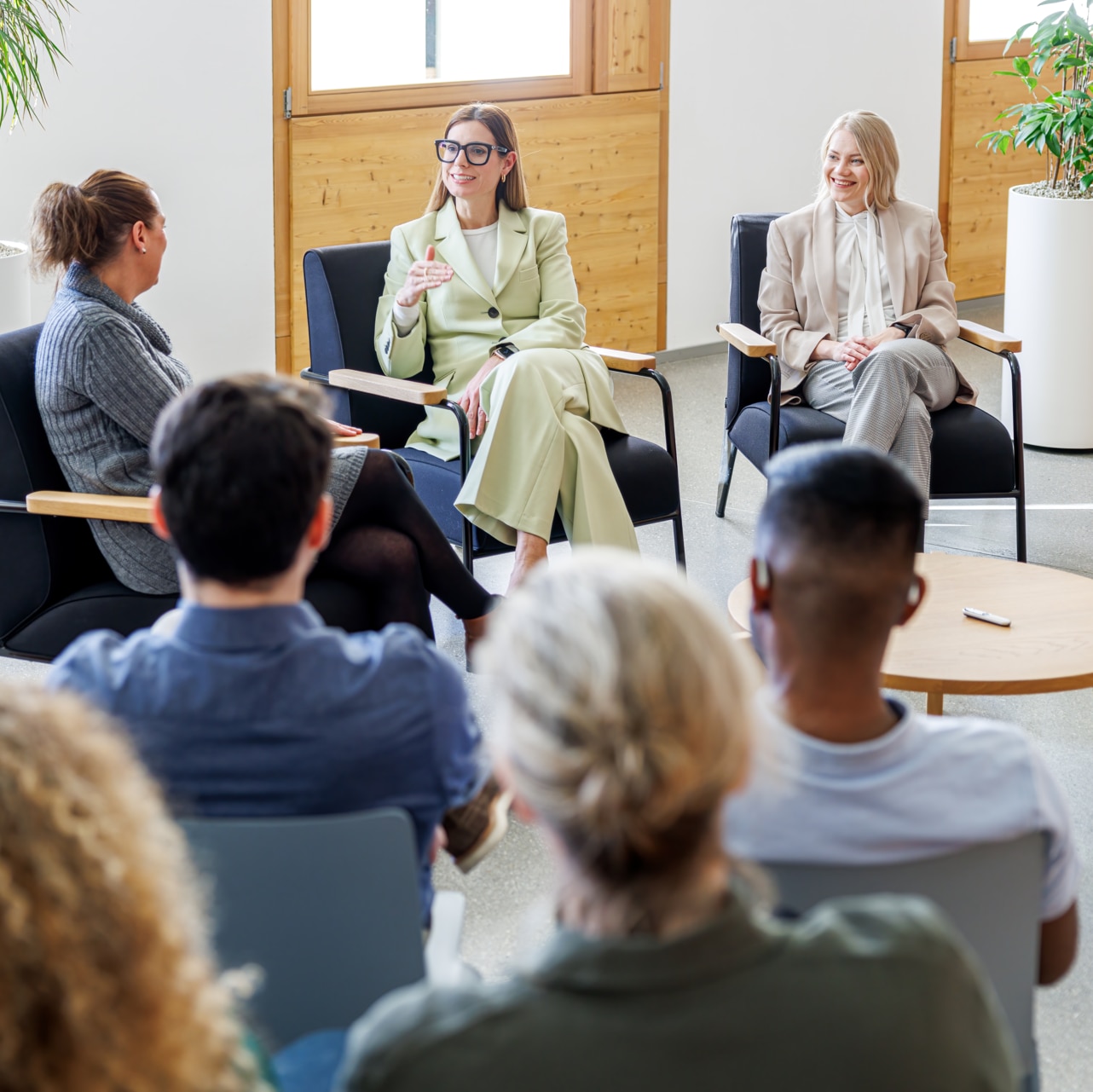 En liten grupp elever som sitter och samtalar. En av dem har Roger On fäst på sitt anteckningsblock.