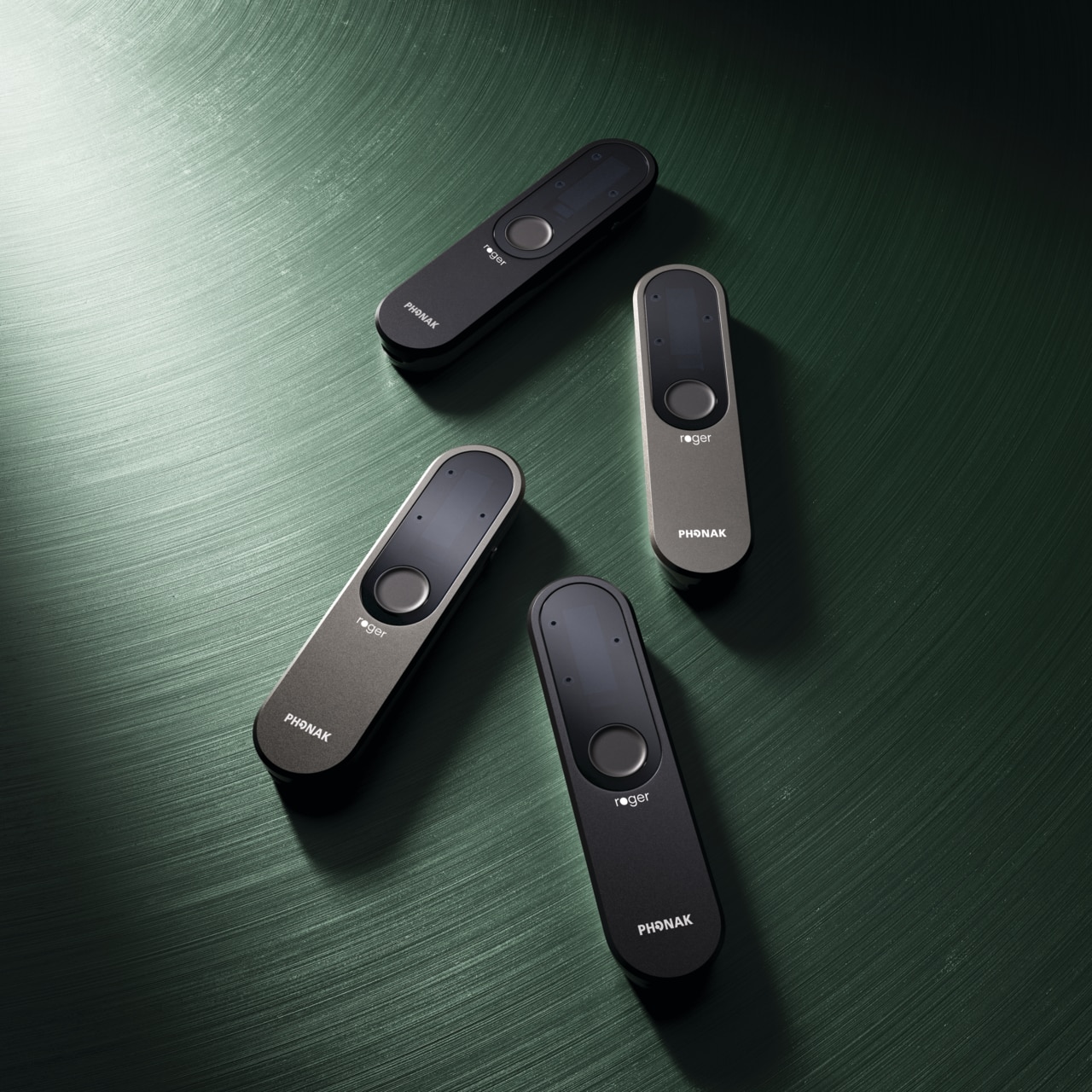 Fyra Roger On-mikrofoner i olika färger på ett grönt bord