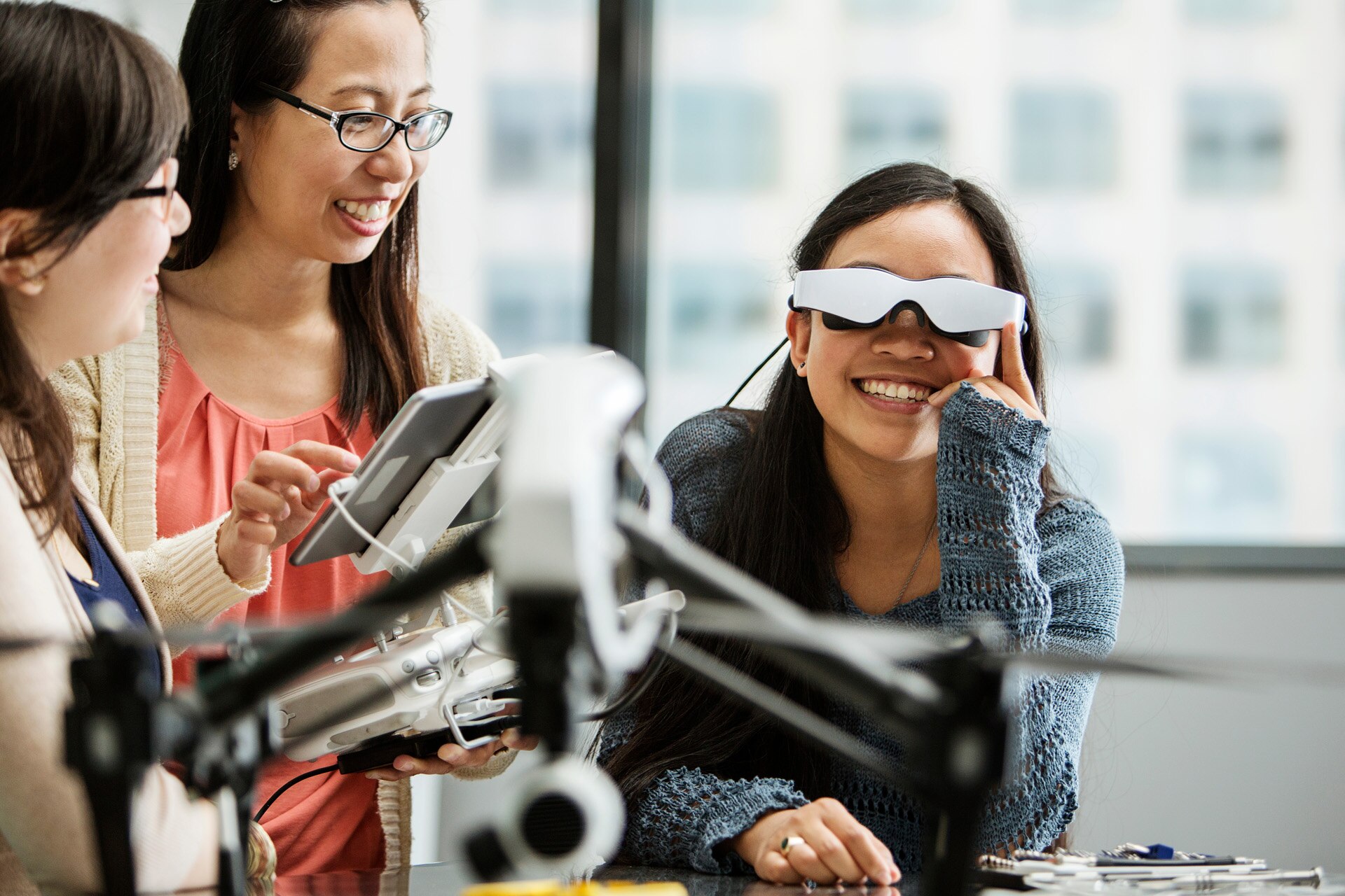 Female student wearing virtual reality glasses while teacher using tablet computer in classroom